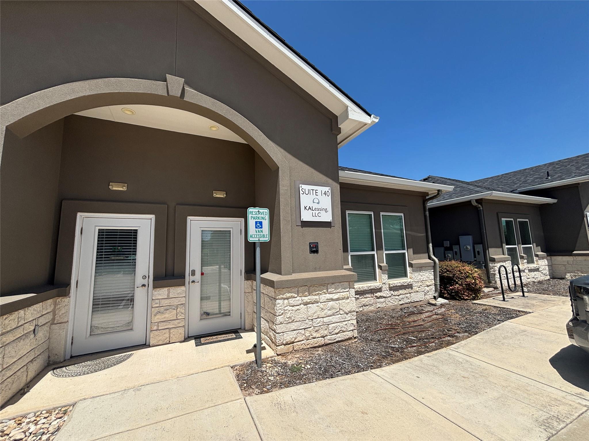 A welcoming stone and stucco entryway features gl