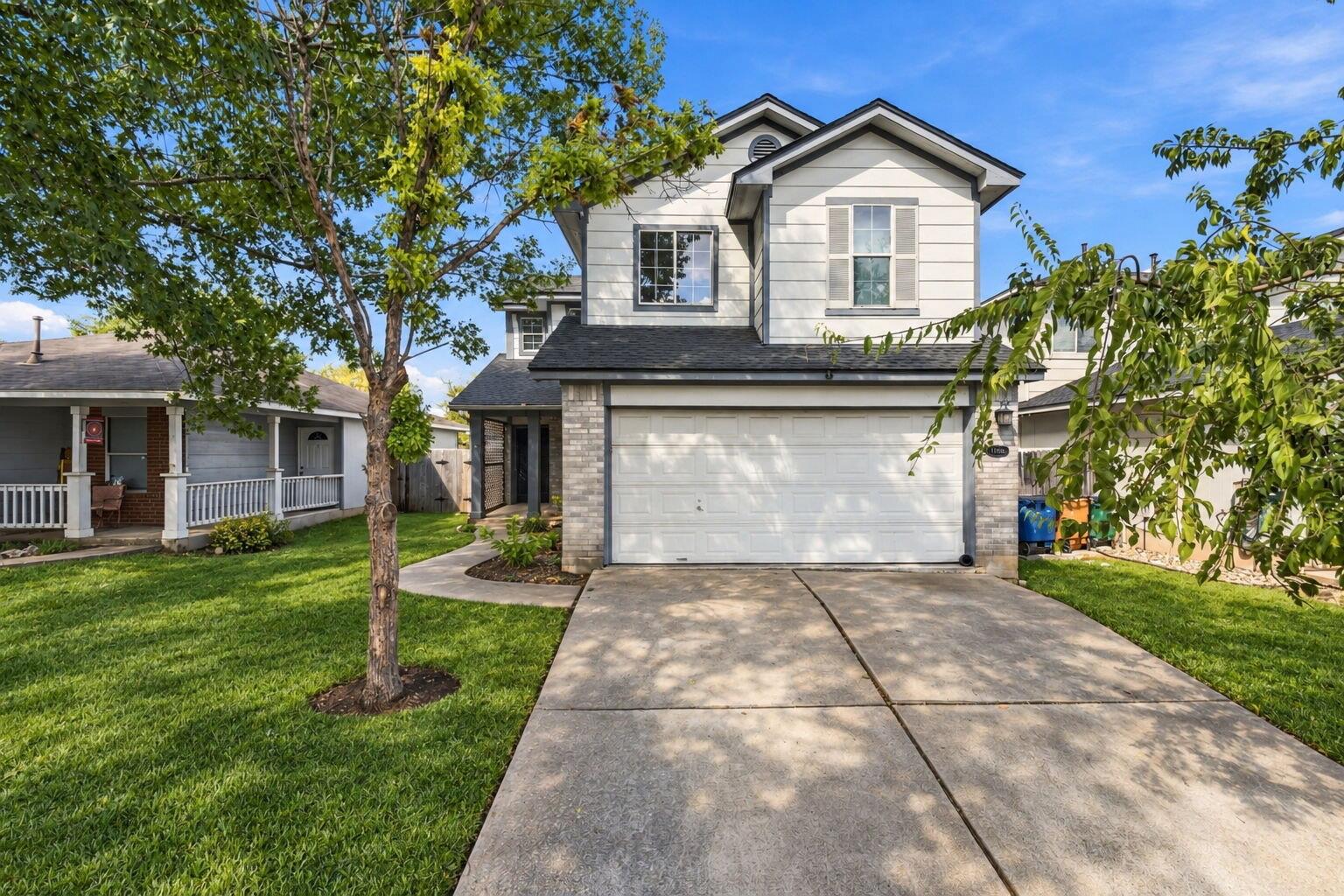 A spacious concrete driveway leads toward a two-s