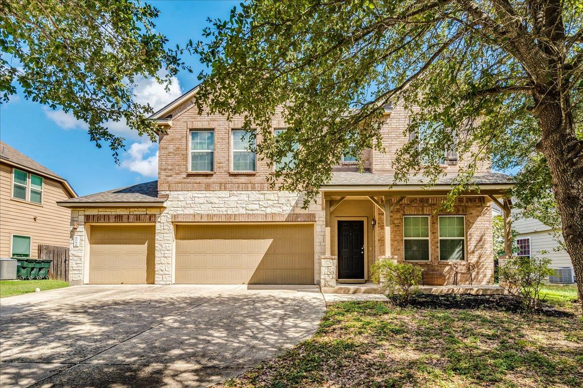 Mature trees shade a classic brick and stone faca