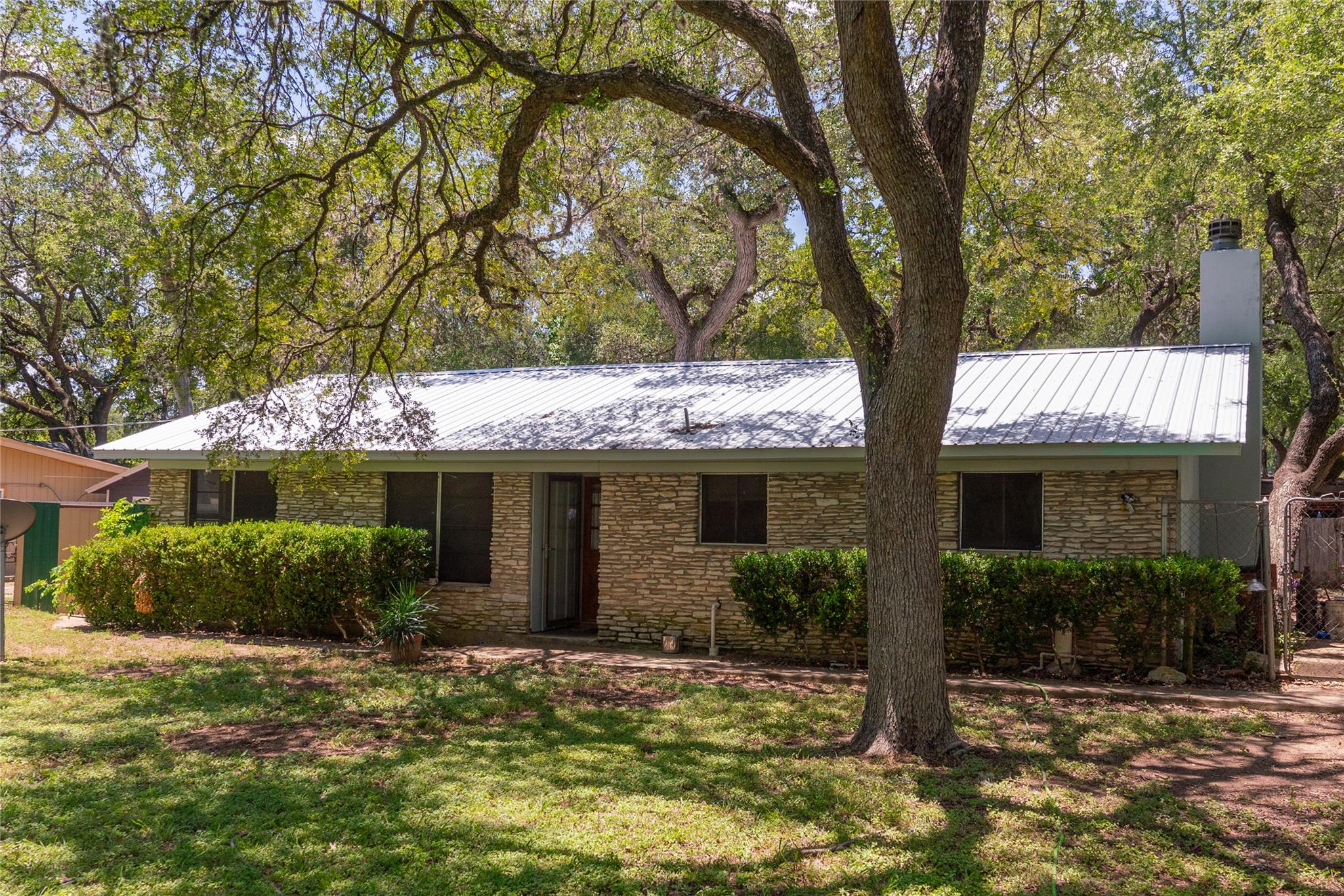Mature trees shade a classic stone exterior toppe