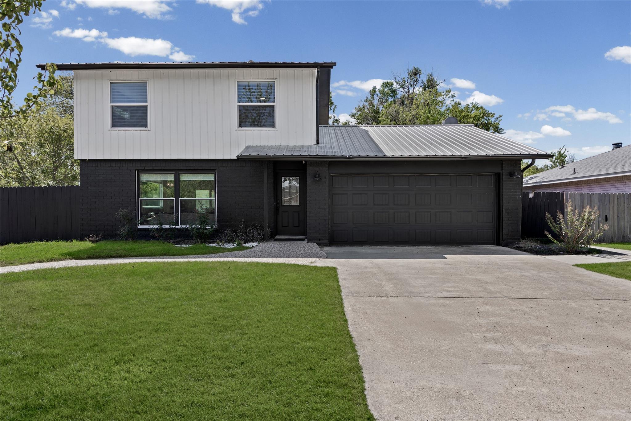 A striking modern exterior pairs dark painted bri