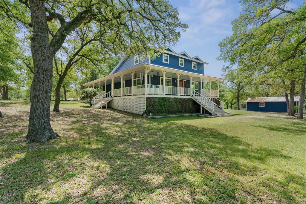 Mature trees shade a spacious lawn surrounding a 