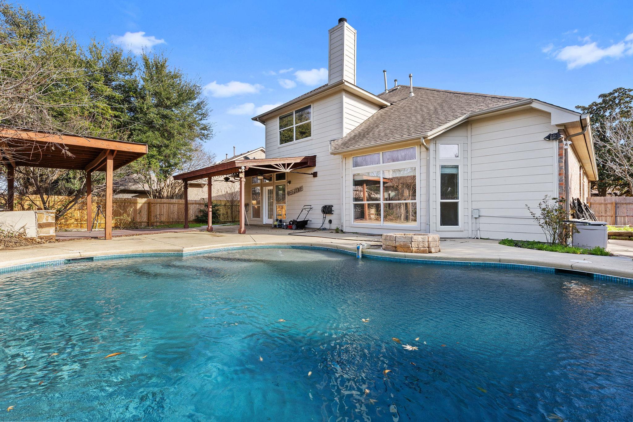 A sparkling swimming pool highlights the backyard