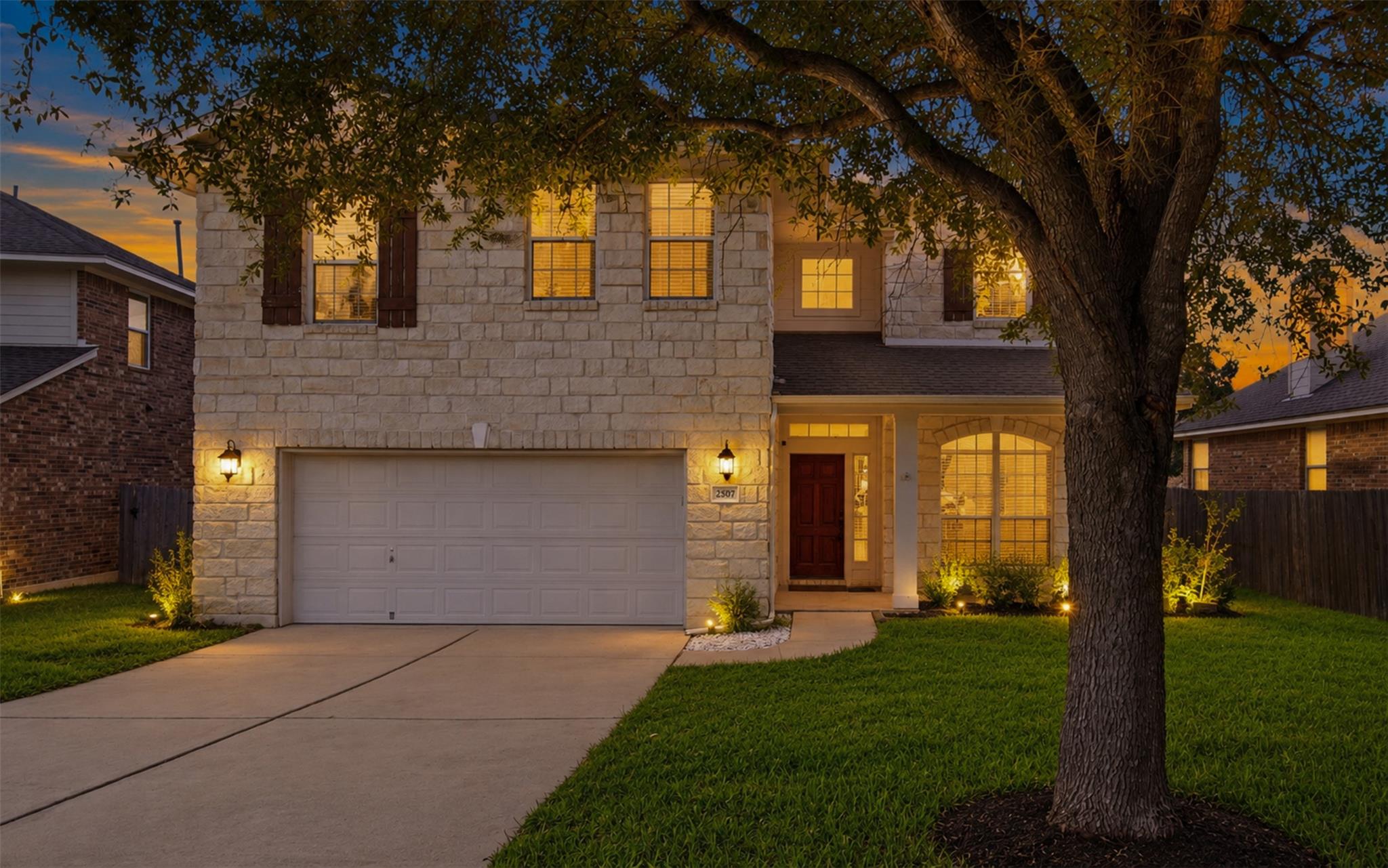 A classic stone exterior and manicured lawn creat