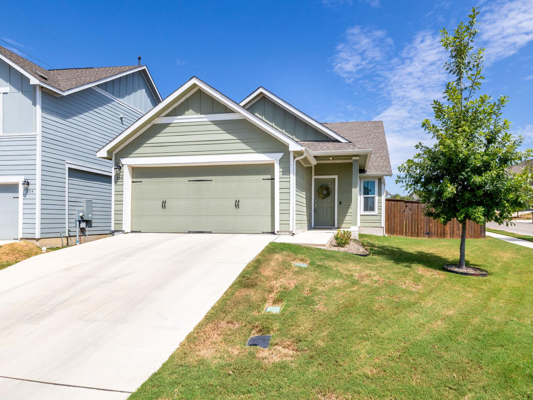Crisp gables and a wide concrete driveway define 