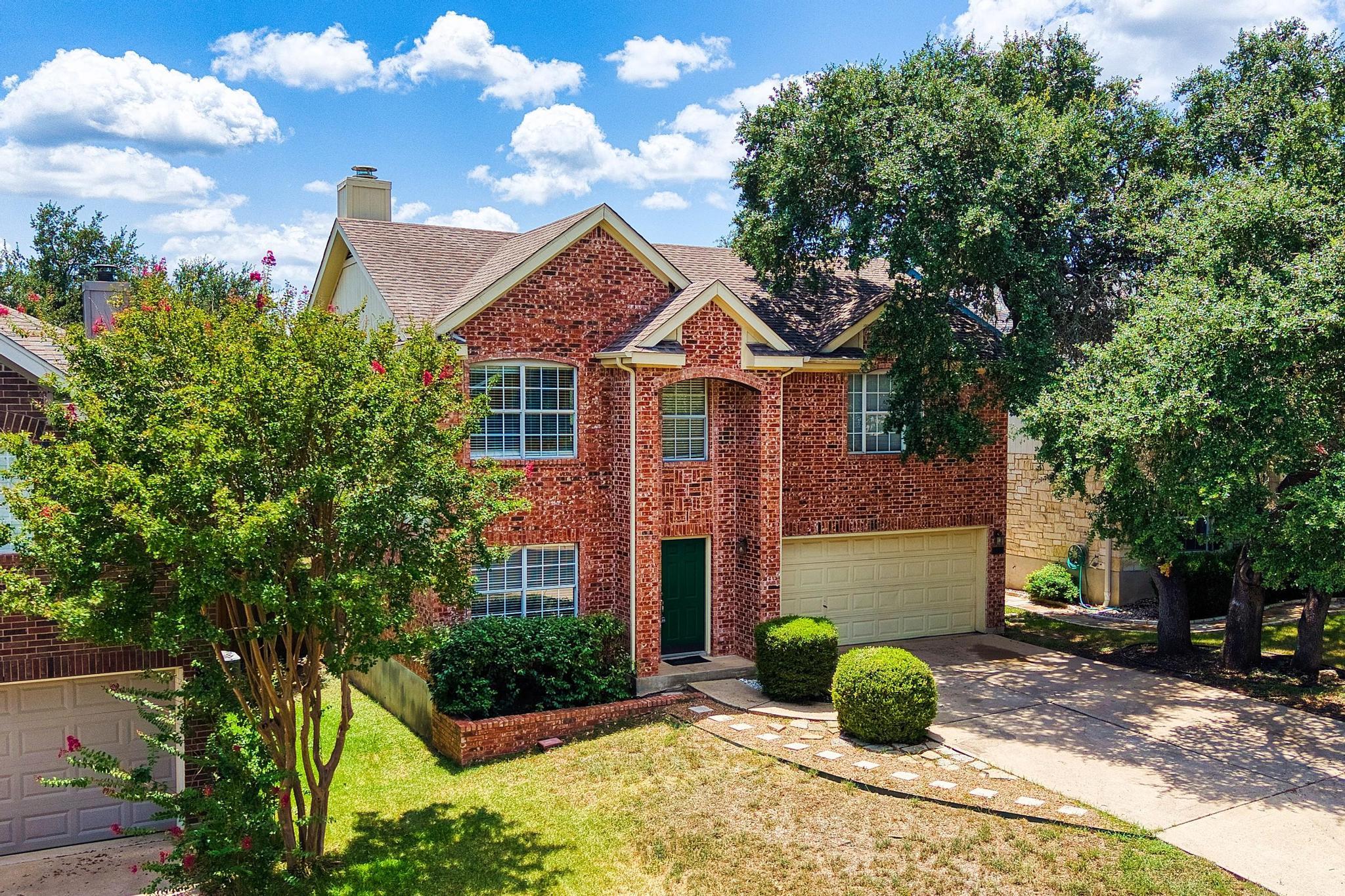 Mature trees shade a classic brick exterior compl