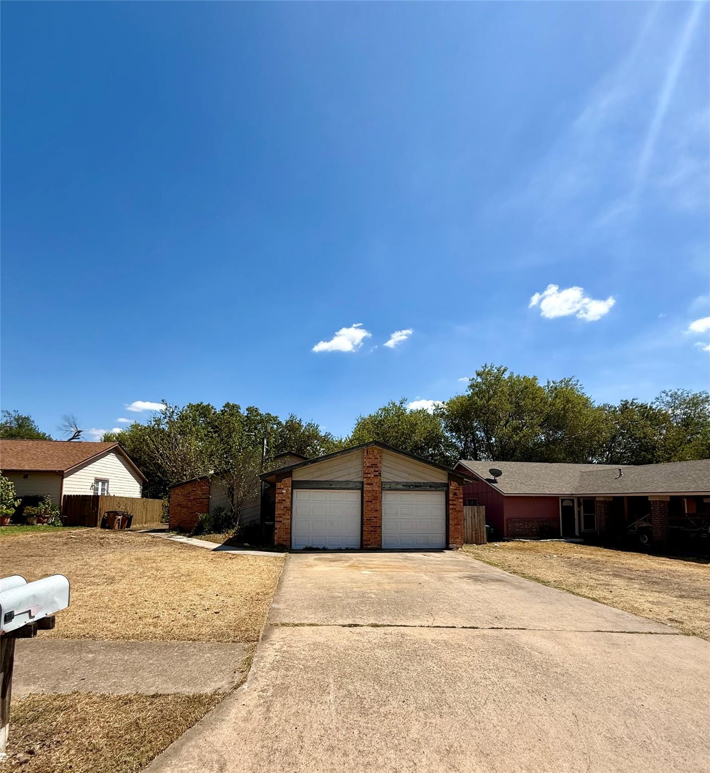 A spacious concrete driveway leads toward a detac
