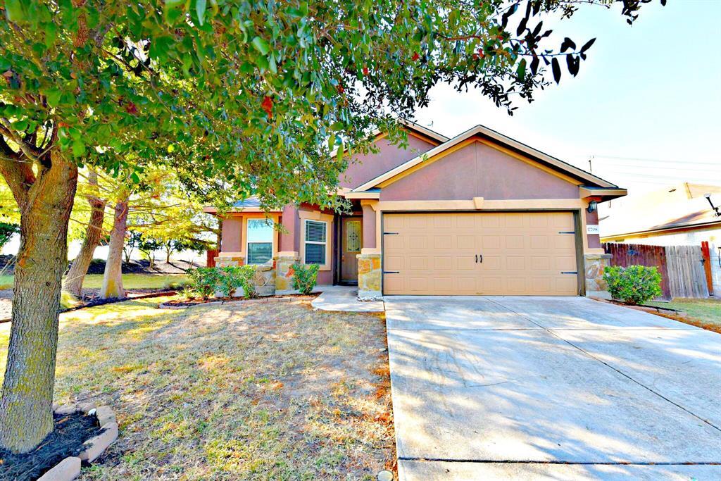 Mature trees shade the front lawn and concrete dr