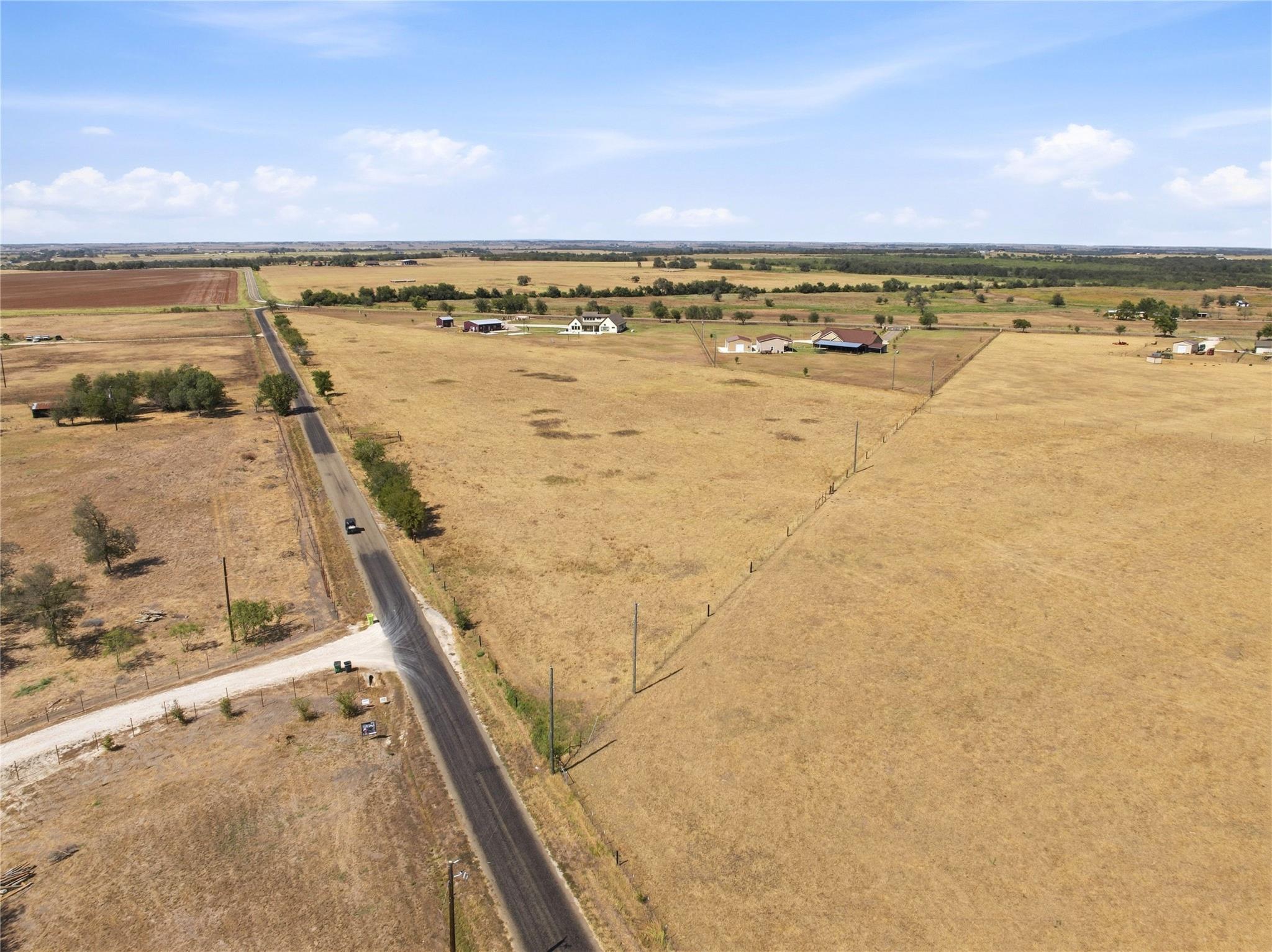 A vast expanse of level pasture borders a quiet p