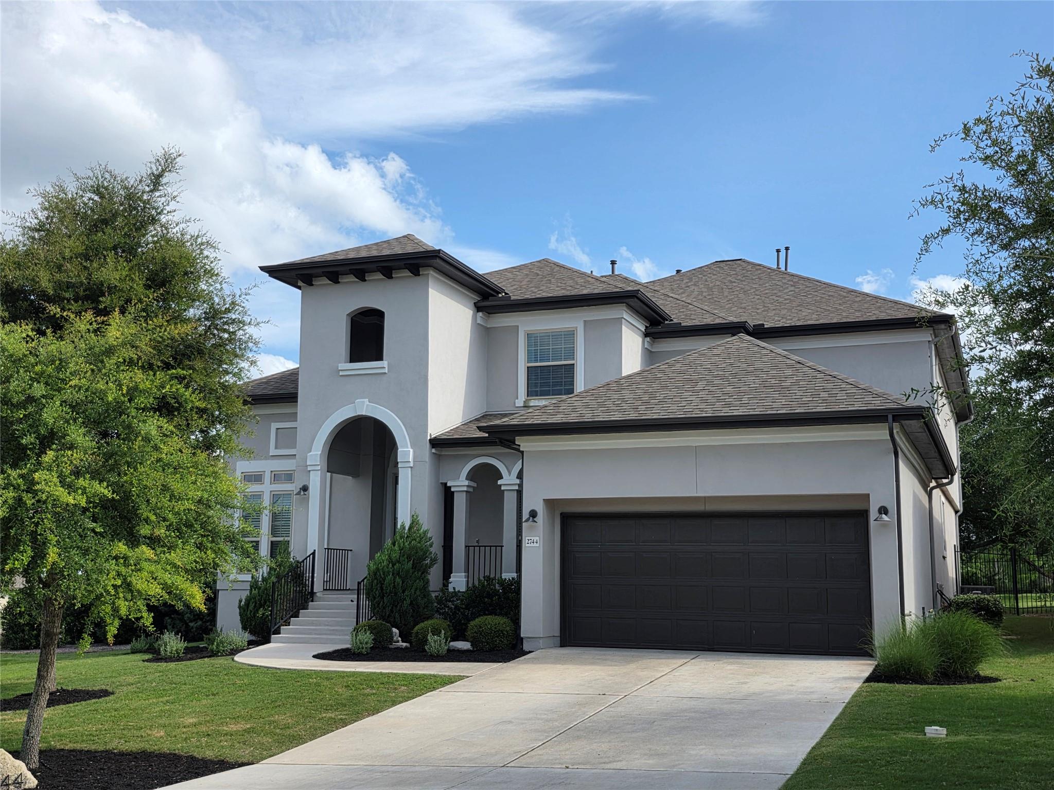 An elegant stucco facade with a multi-gabled roof