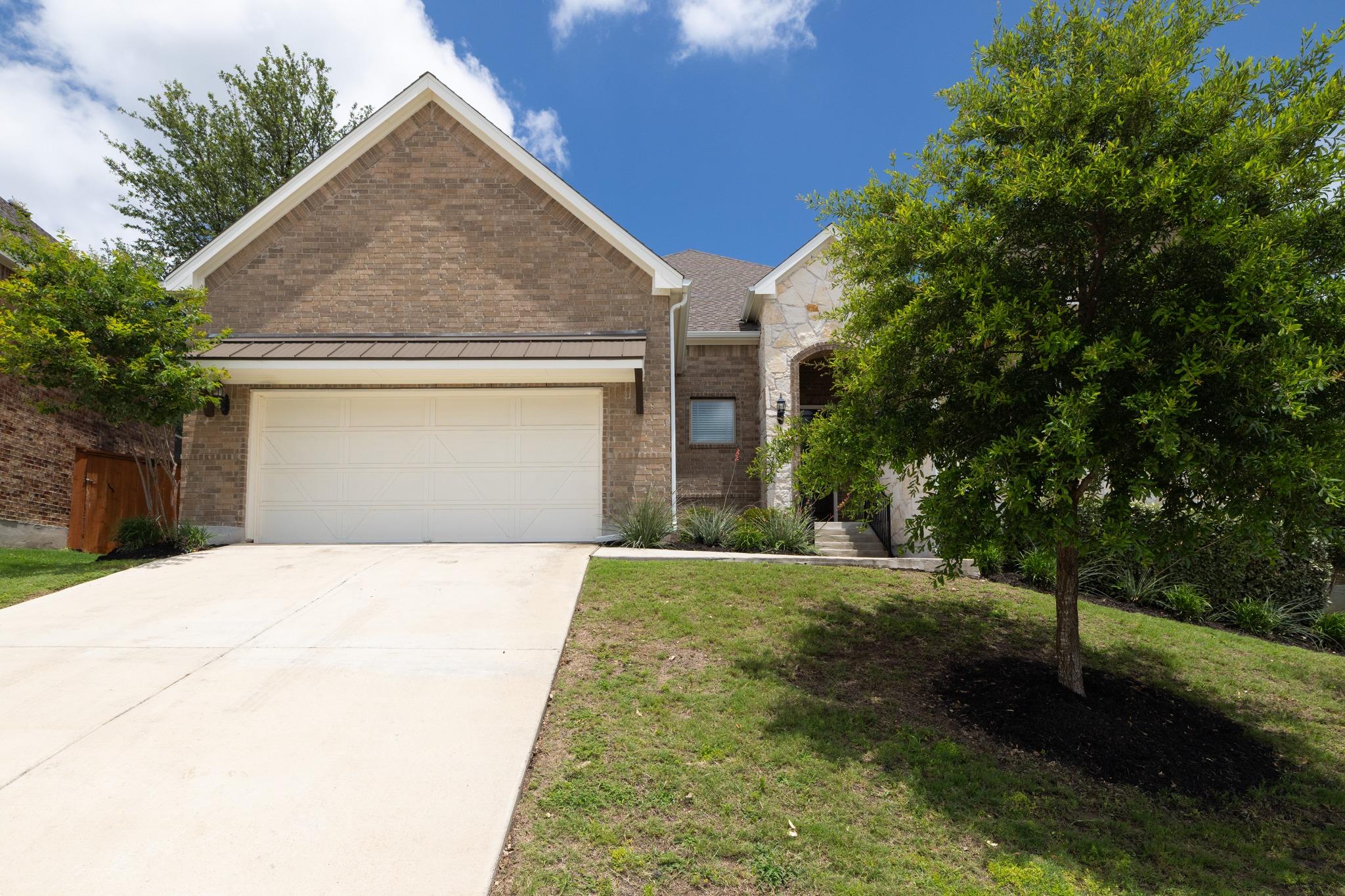 A classic brick exterior and concrete driveway de
