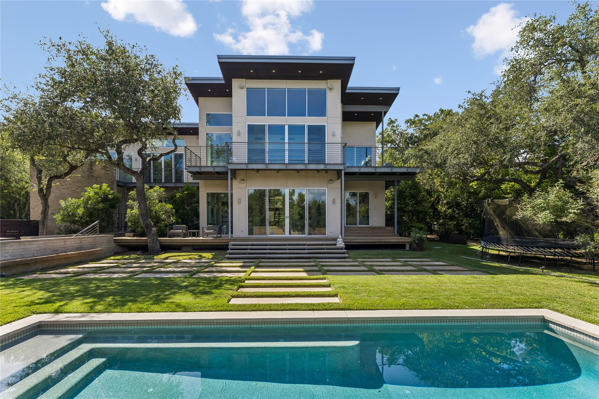 A sparkling in-ground pool fronts this multi-leve