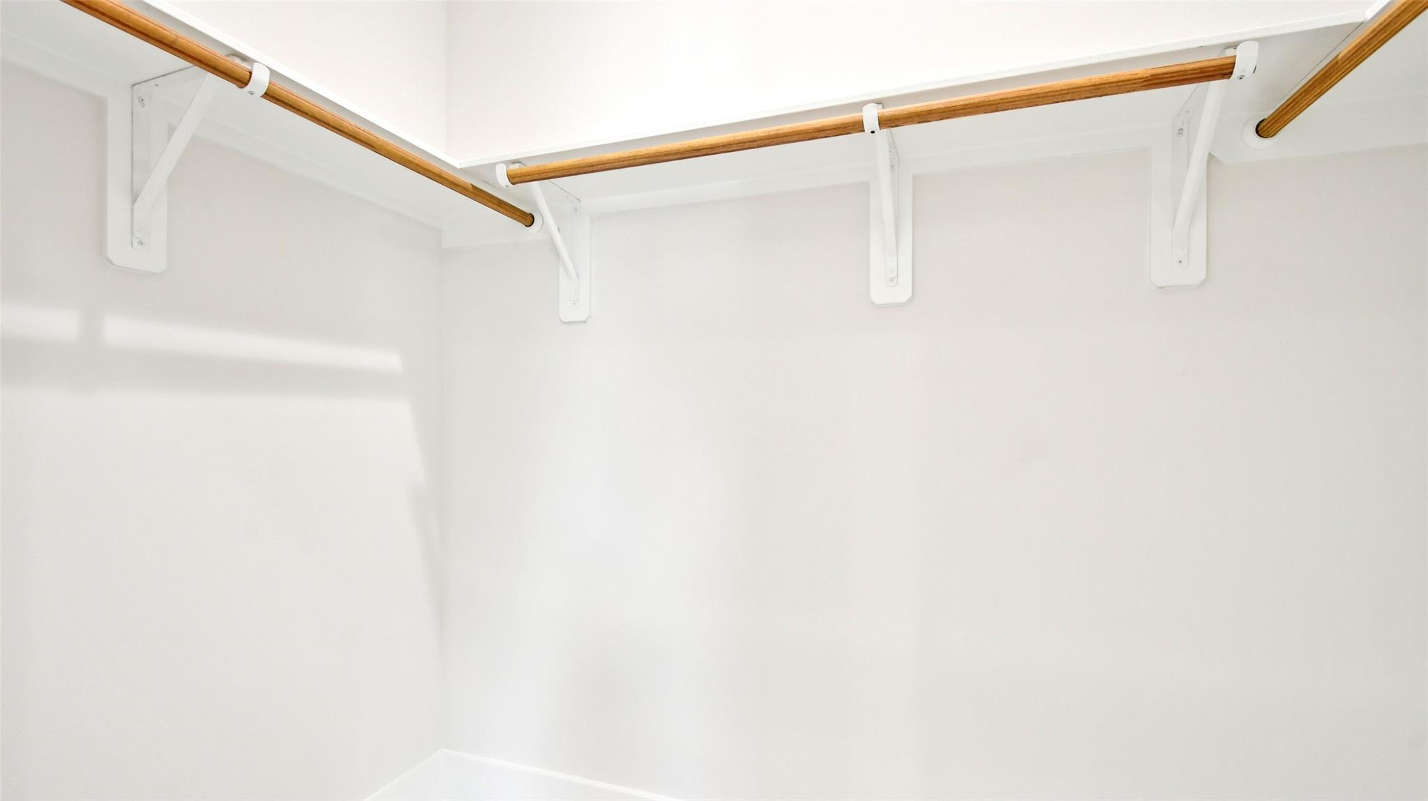 A spacious walk-in closet provides abundant hangi
