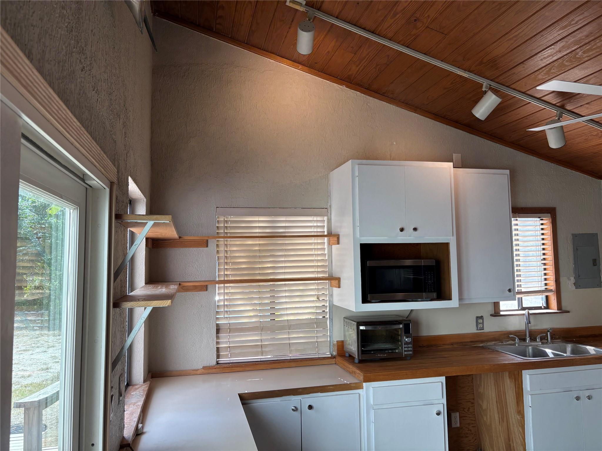 Rich wood plank ceilings and open shelving define