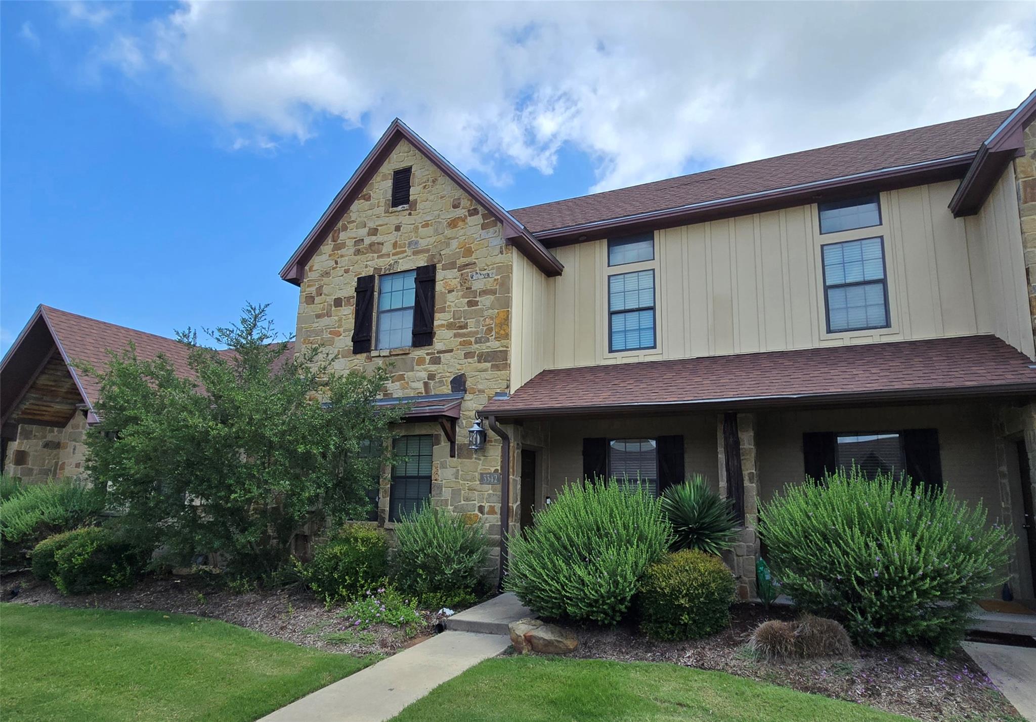 Natural stone accents and vertical siding create 