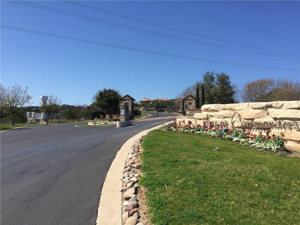 An asphalt driveway leads past manicured landscap