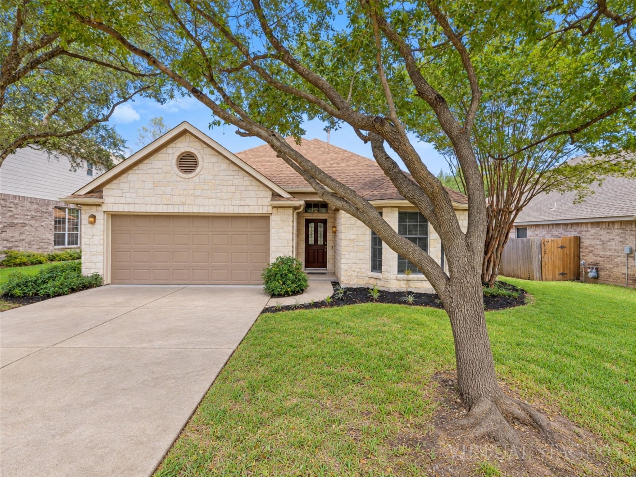 Mature trees frame a classic stone exterior with 