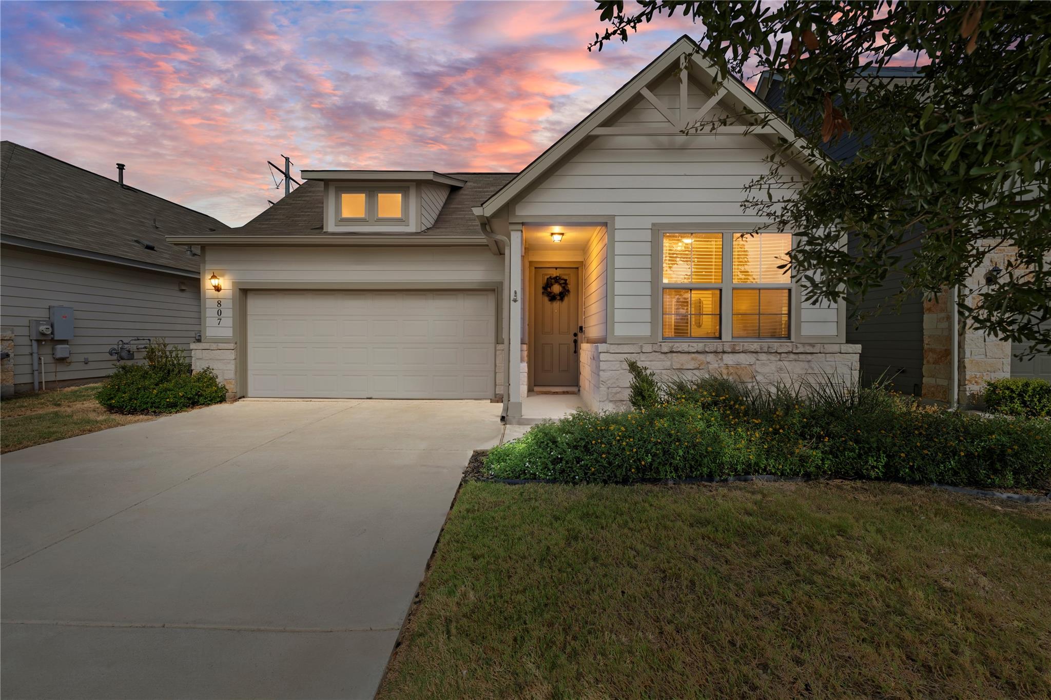 An inviting exterior features a concrete driveway