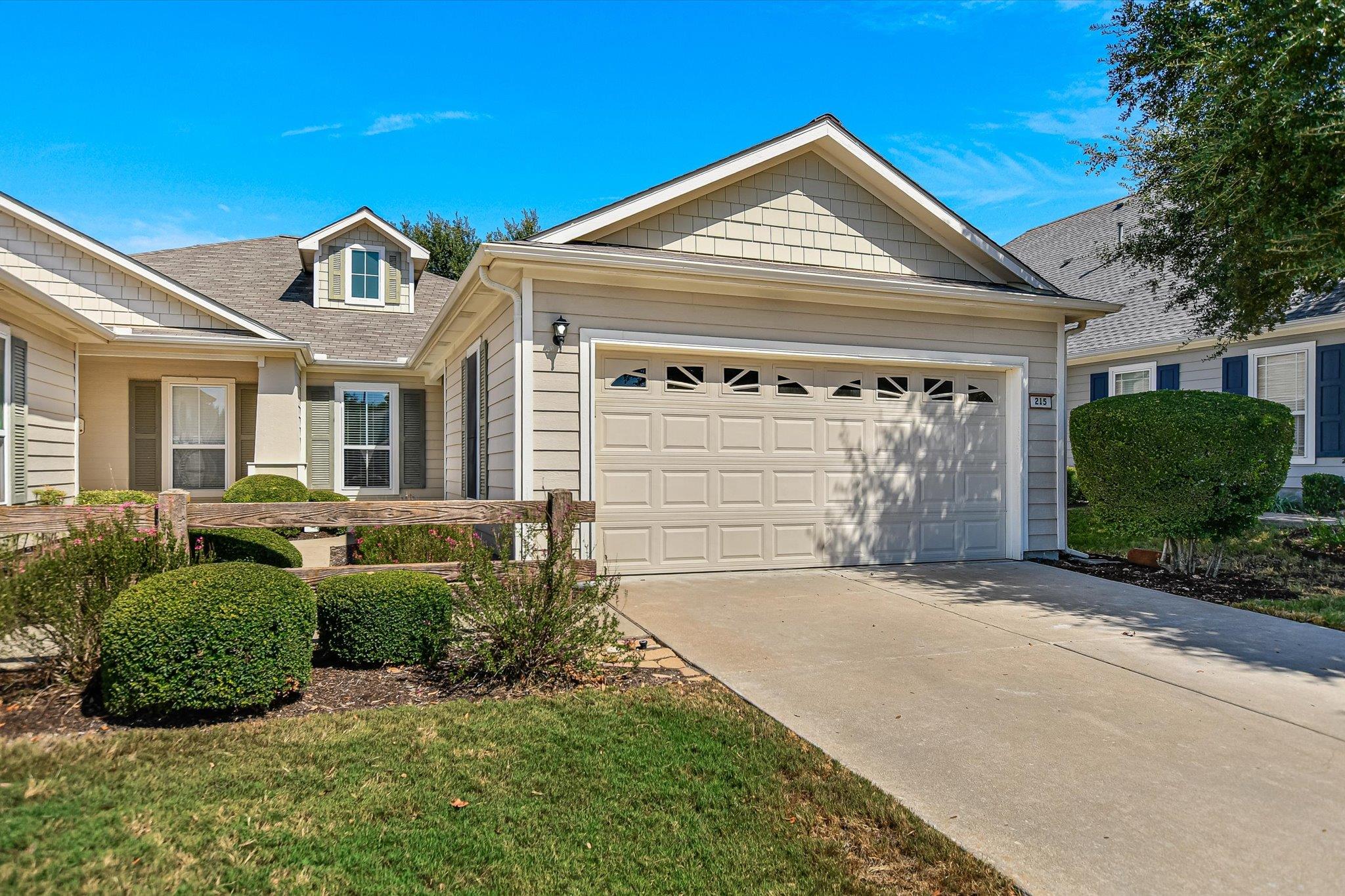 Shingle accents, a neat lawn, and a concrete driv