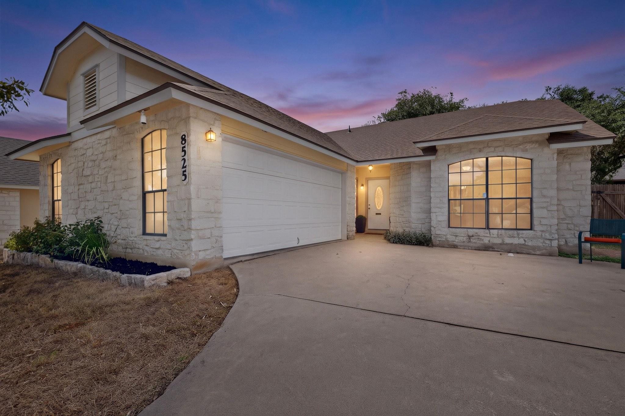 Textured stone siding and a wide concrete drivewa