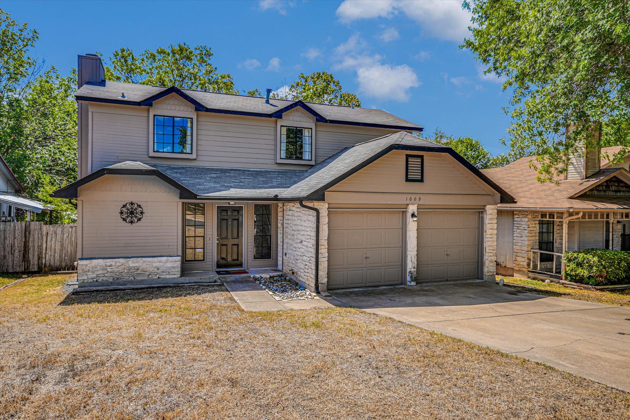 A classic two-story exterior features stone accen