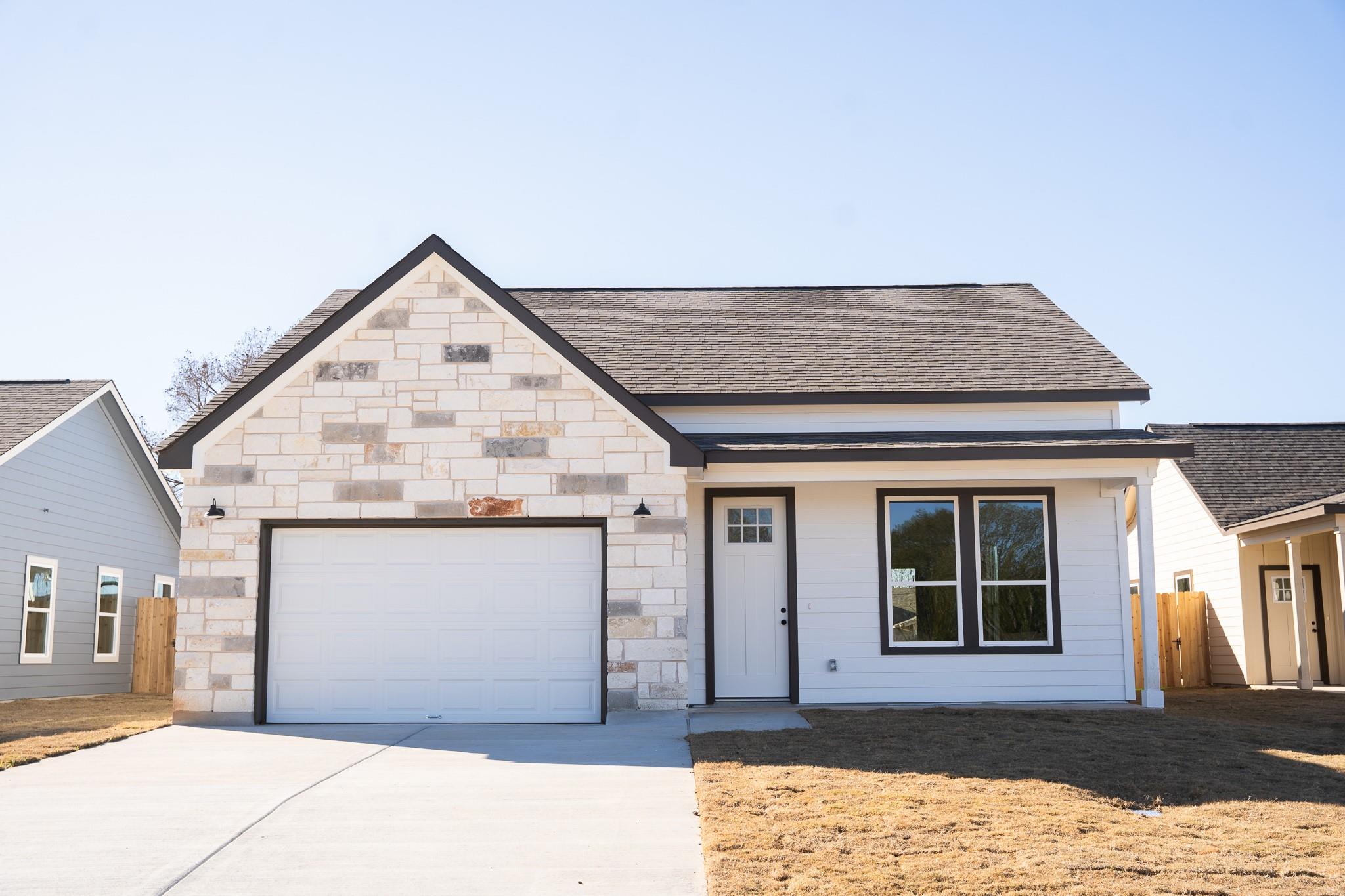View of front facade featuring driveway, an attac