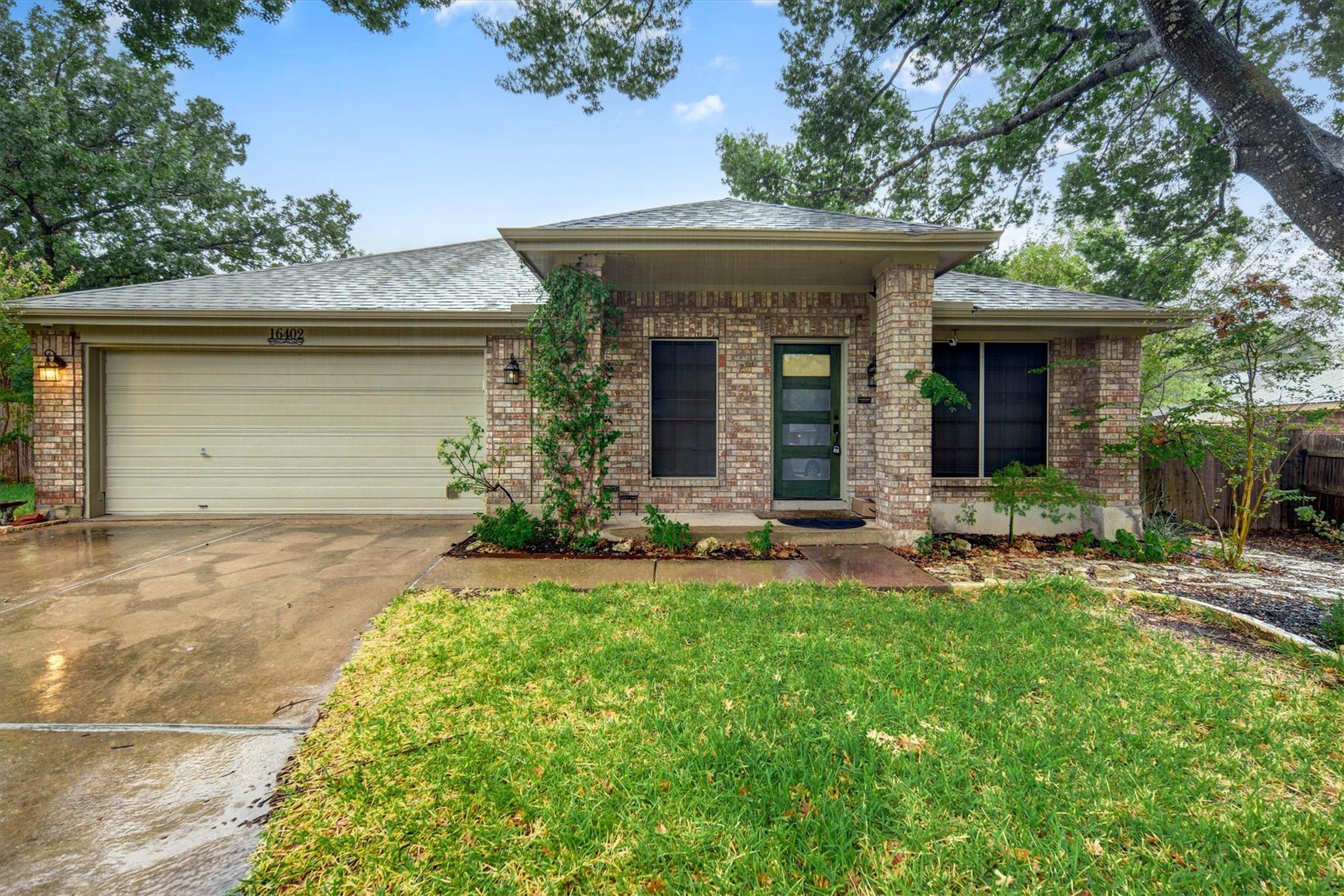 Mature trees shade a classic brick facade with an
