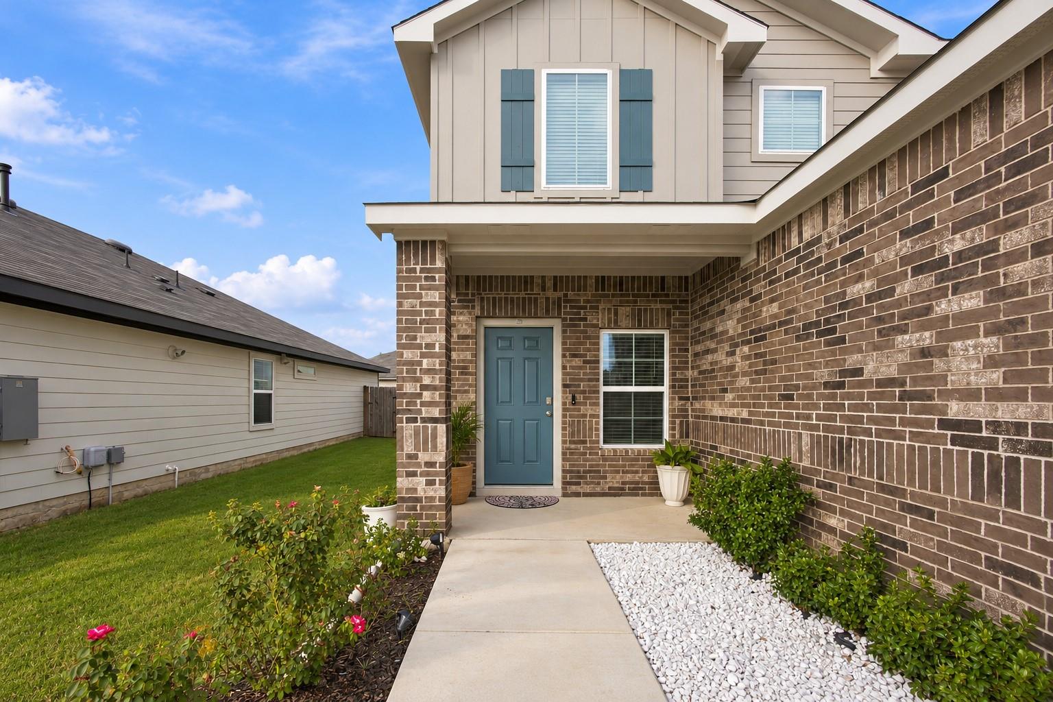 A concrete walkway leads past manicured landscapi