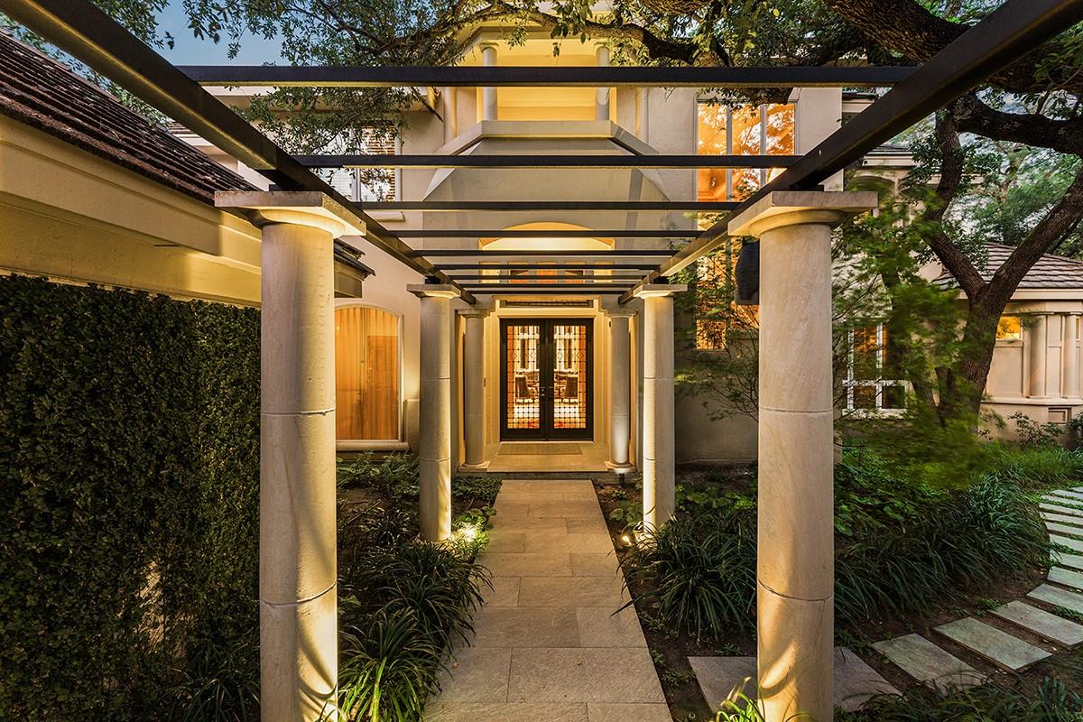 An elegant stone pathway and modern pergola lead 