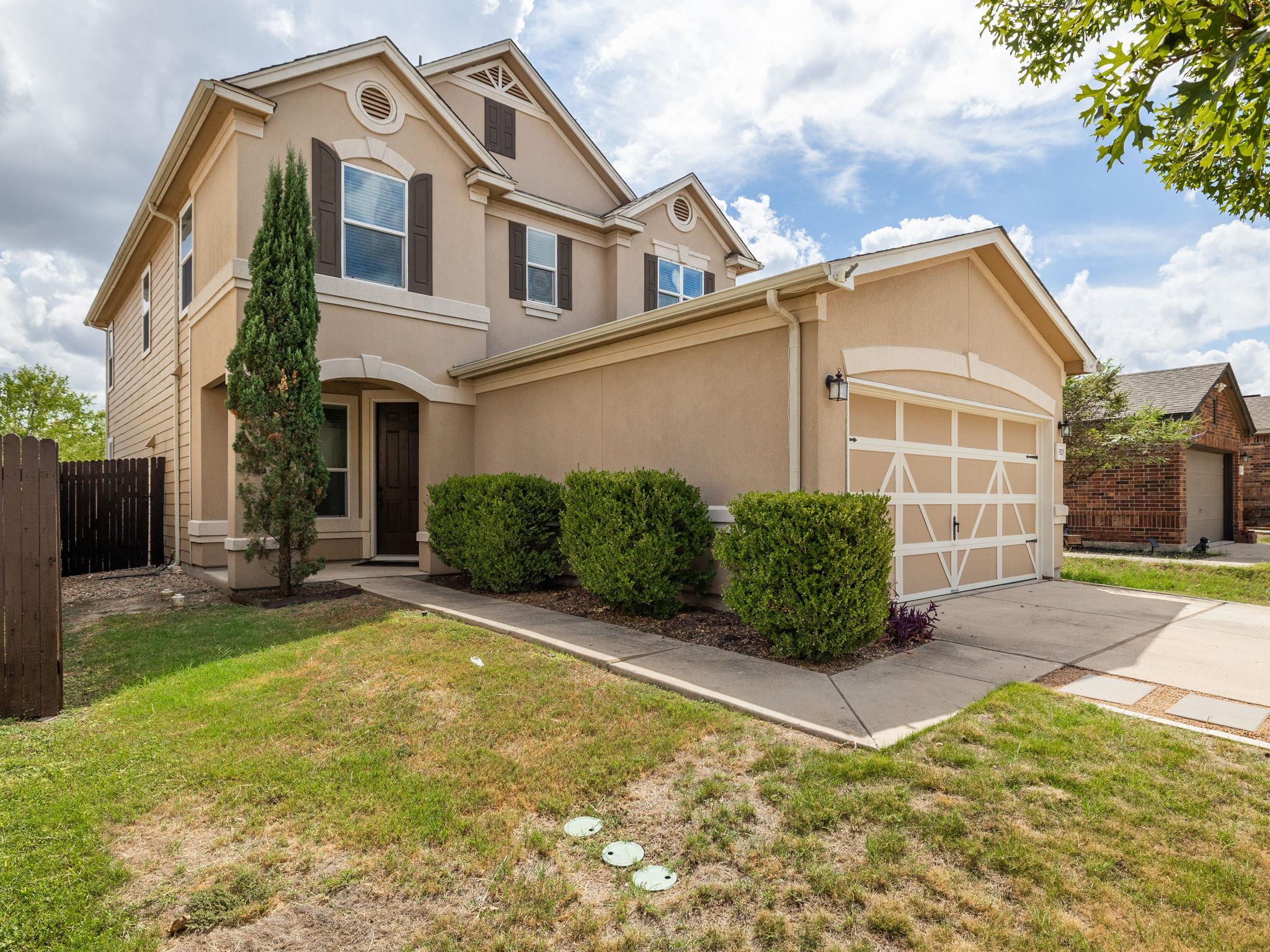 A classic stucco exterior features a concrete dri