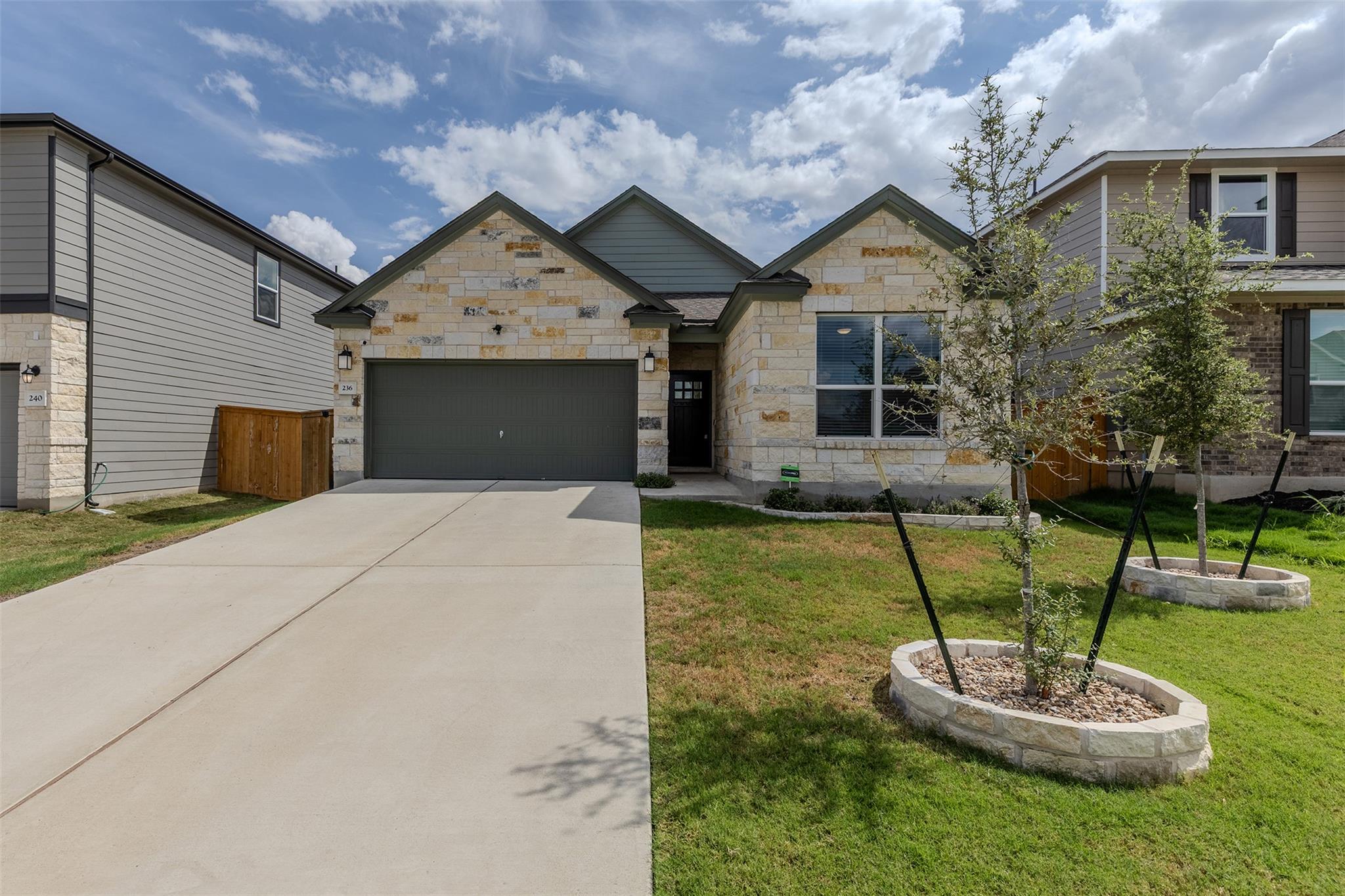 A spacious concrete driveway leads toward a two-c