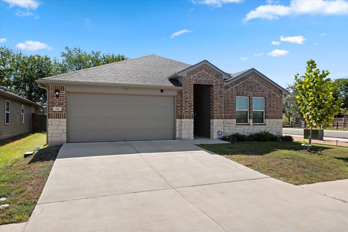 A spacious concrete driveway leads to the brick f