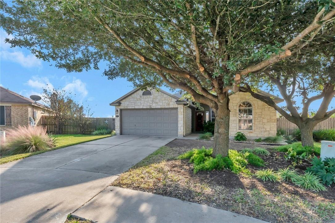 Mature shade trees frame a classic stone facade a
