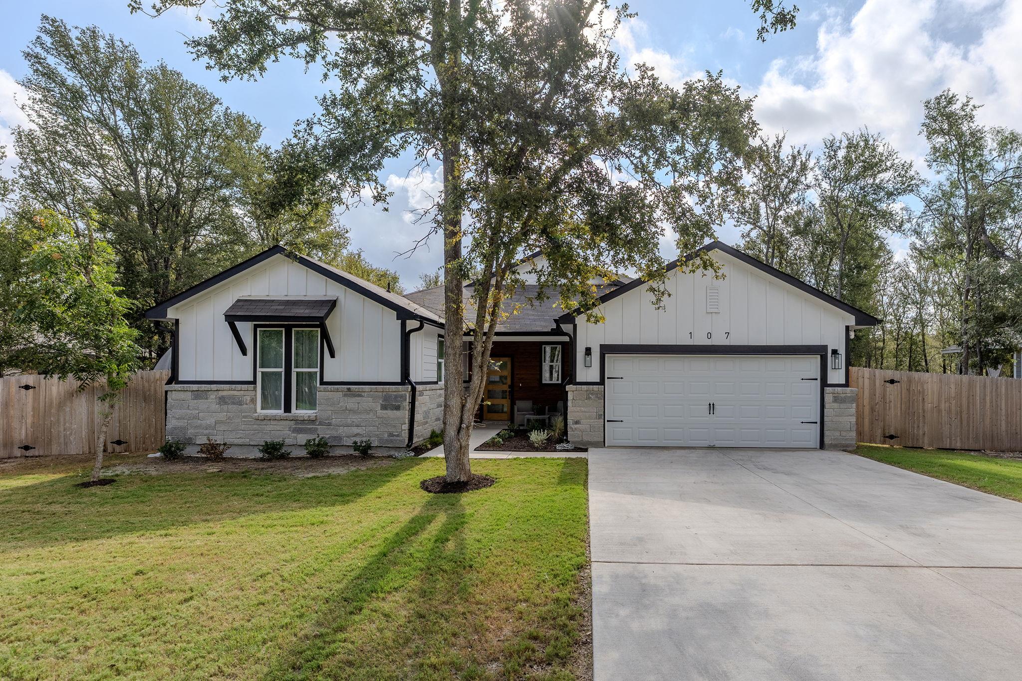 Crisp white siding meets rustic stone accents on 