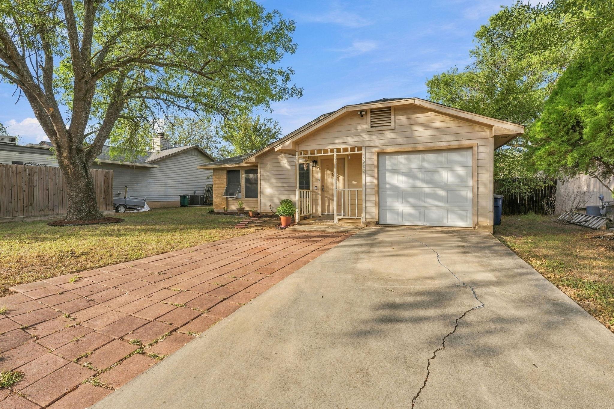 Mature shade trees frame the welcoming entrance a