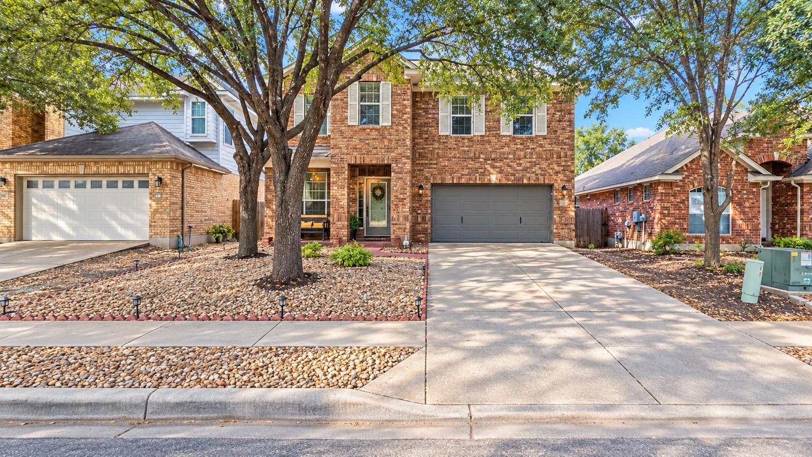 Mature trees shade the classic brick exterior and