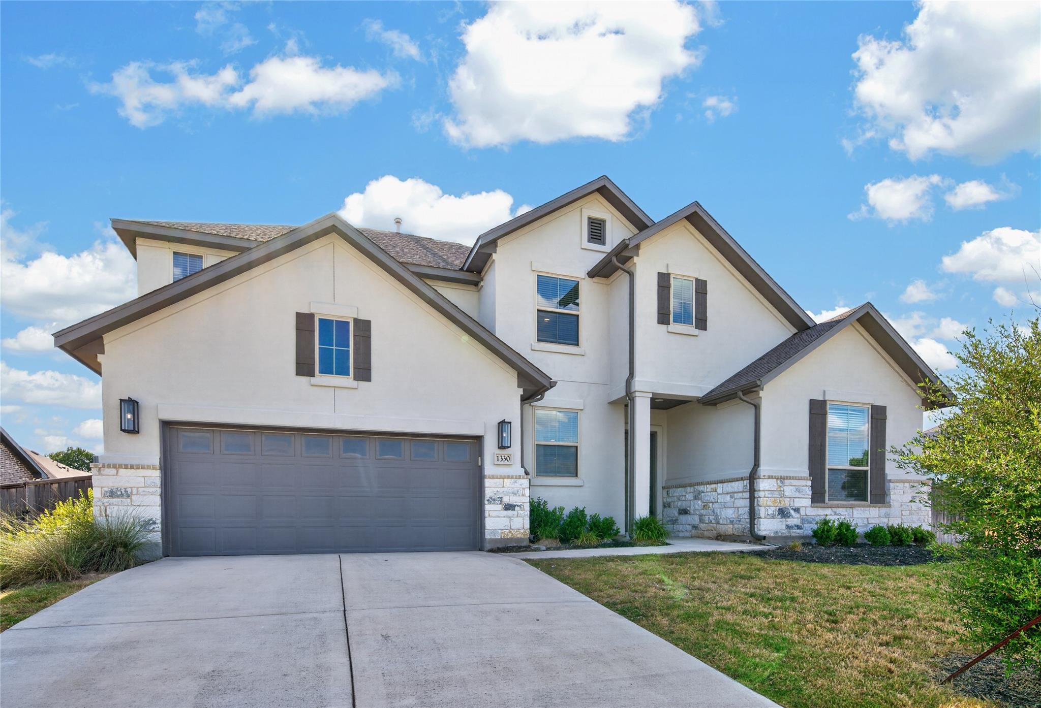 An inviting stone and stucco exterior anchors thi