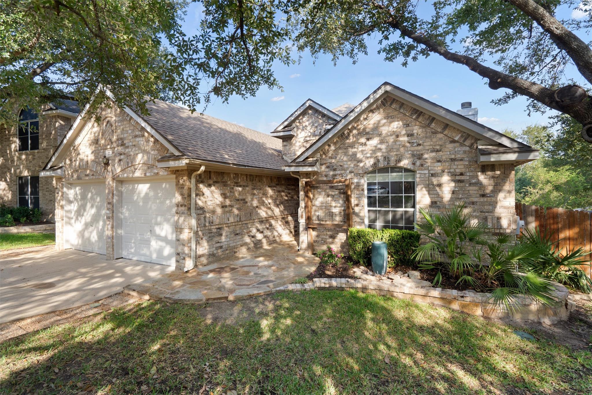 Mature trees shade a classic brick exterior featu