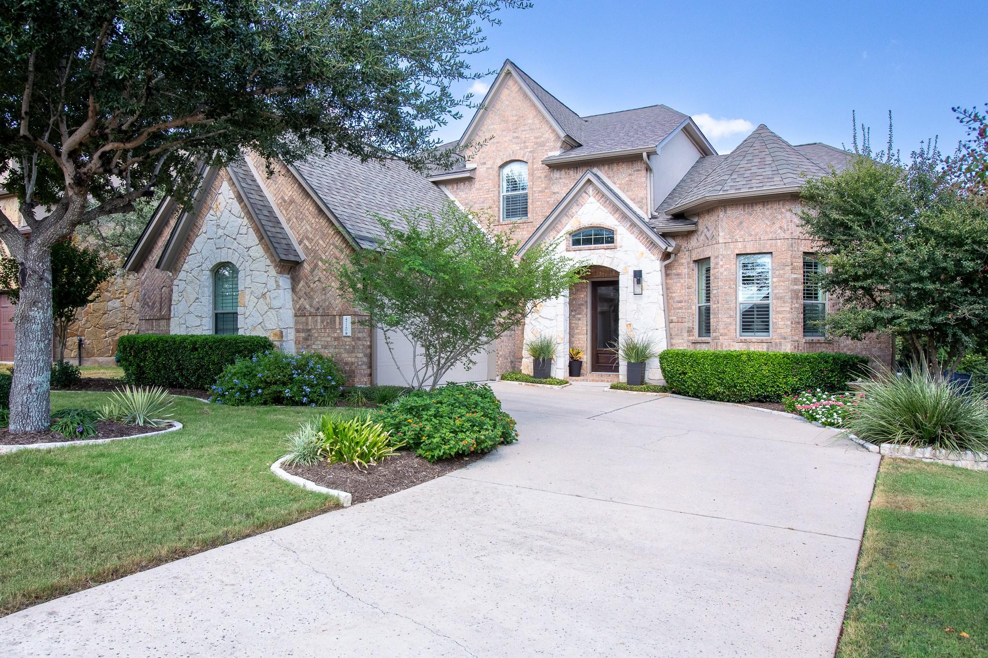 An elegant brick and stone facade meets manicured