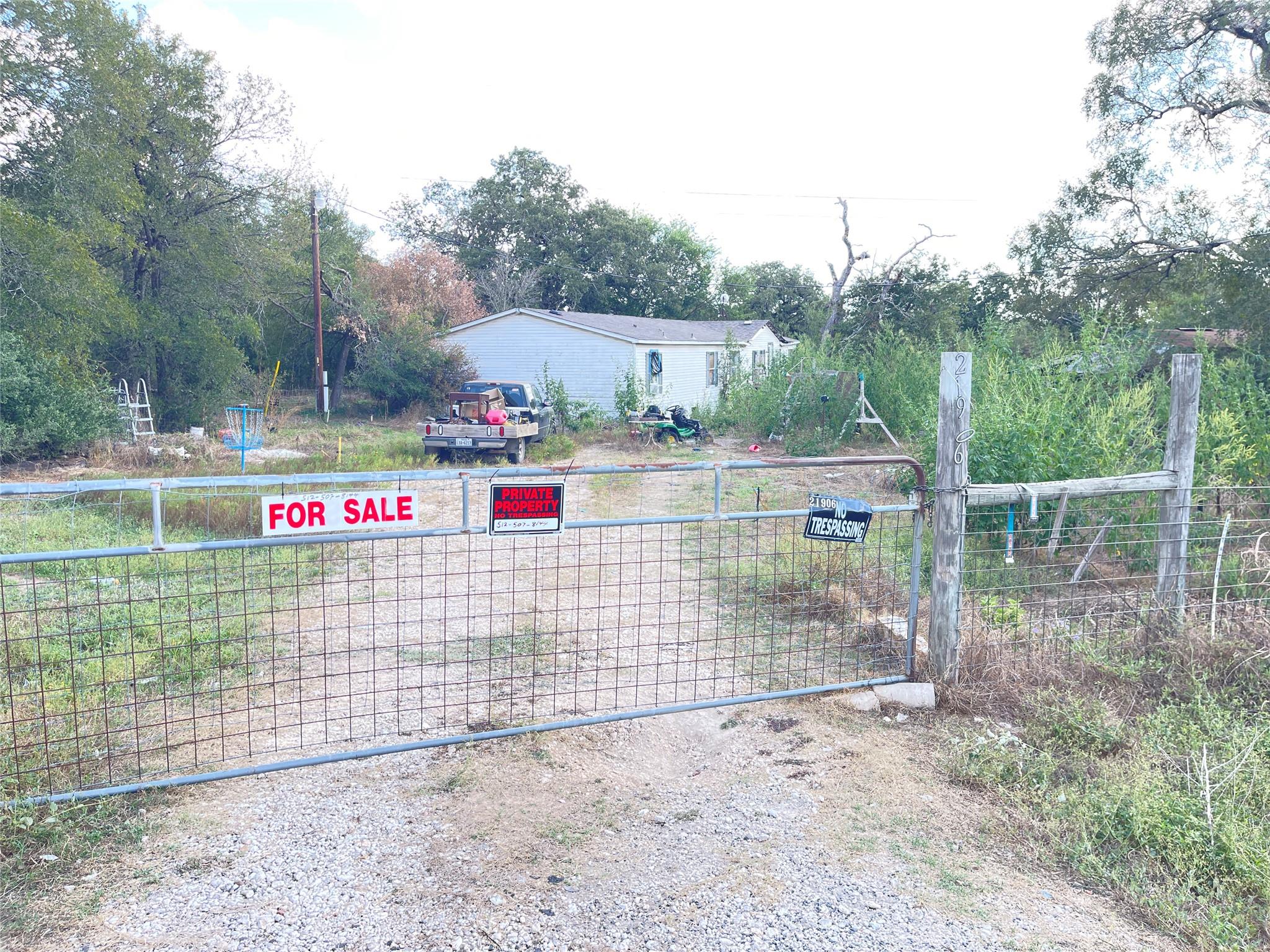 Gated entry opens to a private drive leading towa