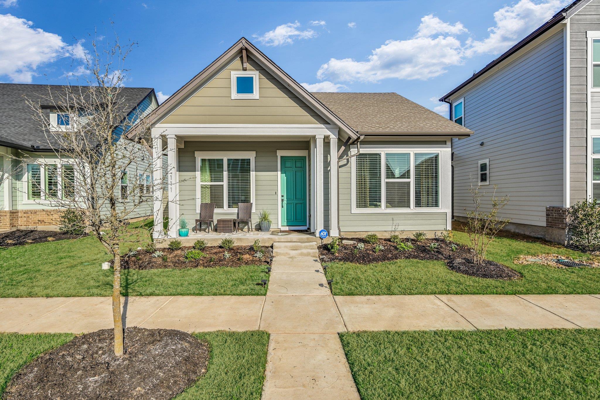 Shotgun-style home with a porch and a front lawn