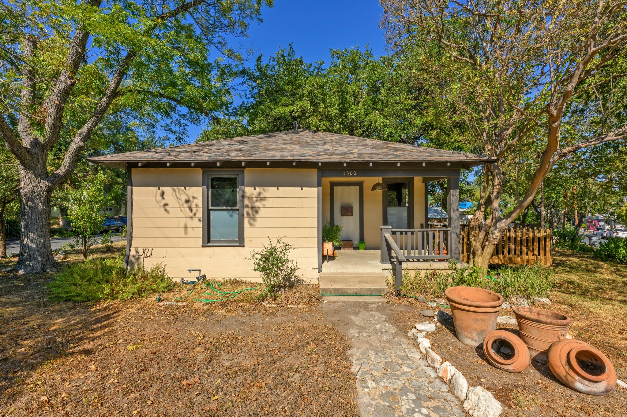 Mature trees frame a charming classic cottage wit