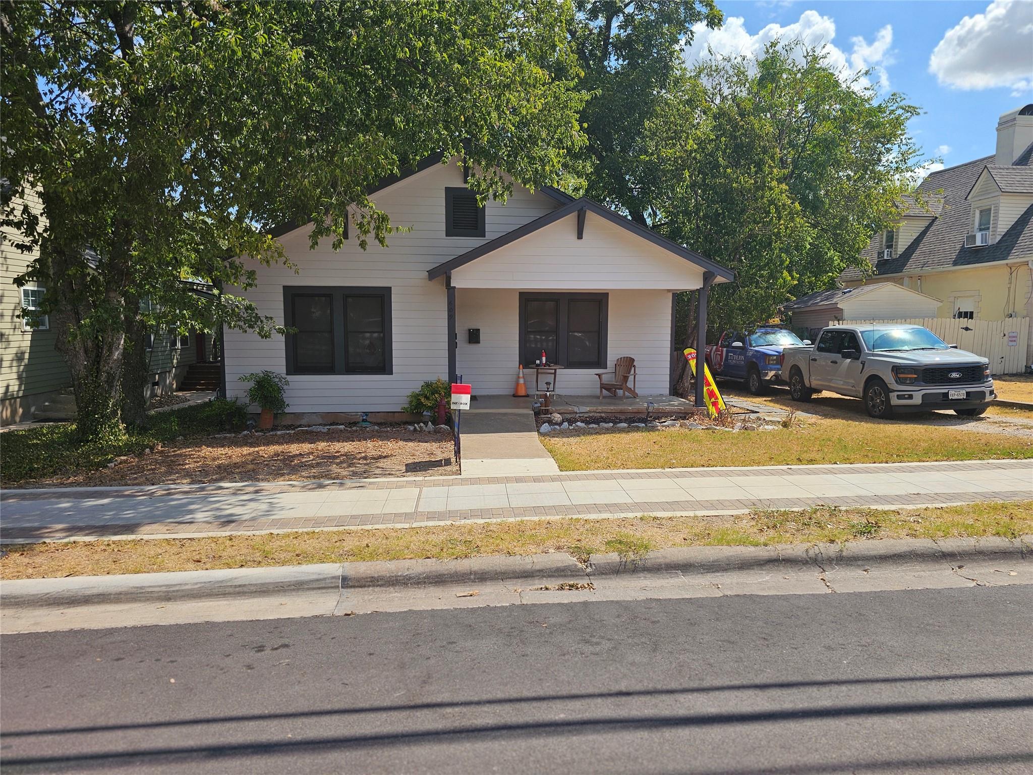 Mature trees shade the front porch and classic si