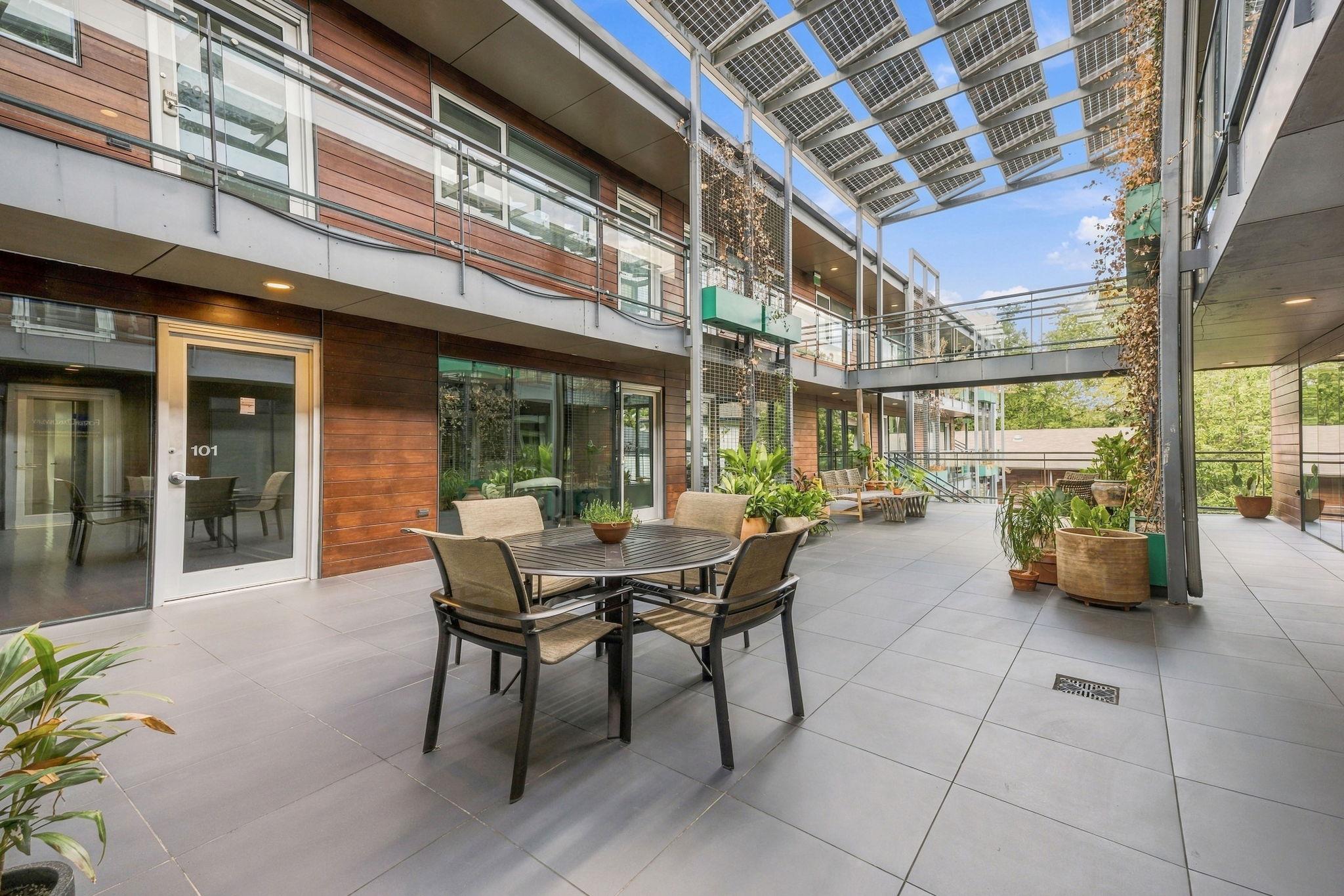 A spacious shared courtyard patio under a solar p