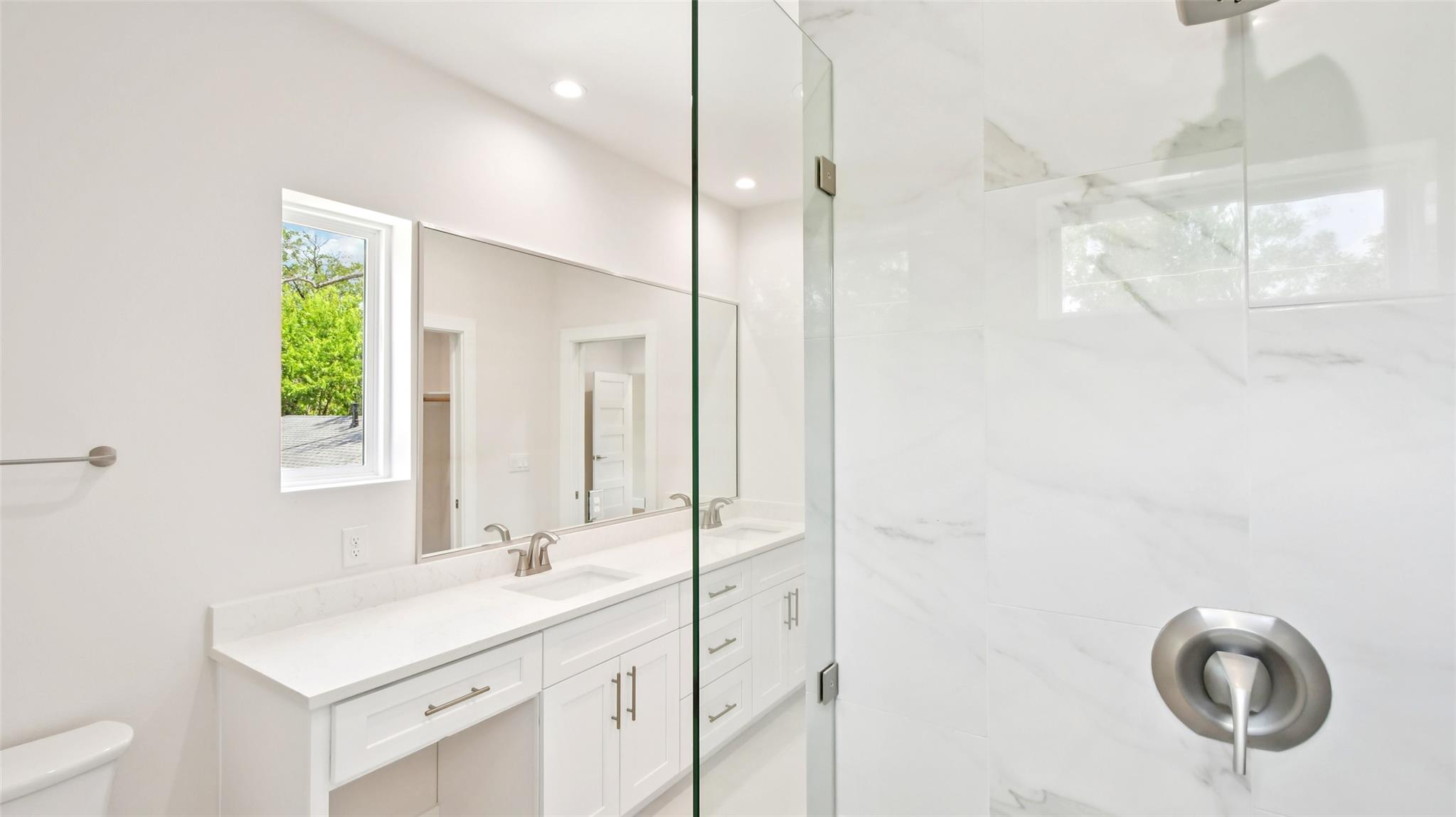 Polished tile surrounds a glass shower enclosure 