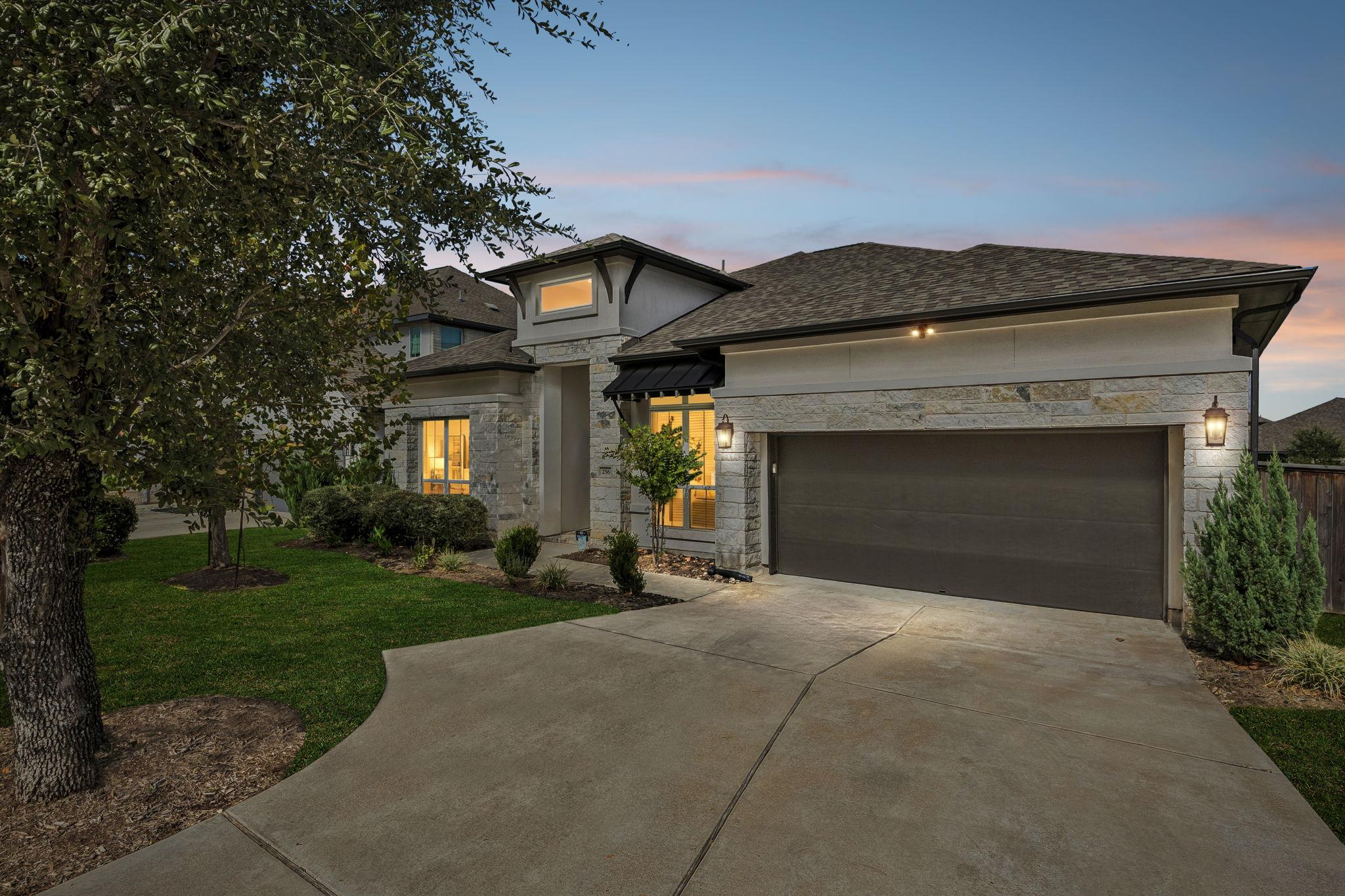 An inviting stone facade and wide driveway lead t