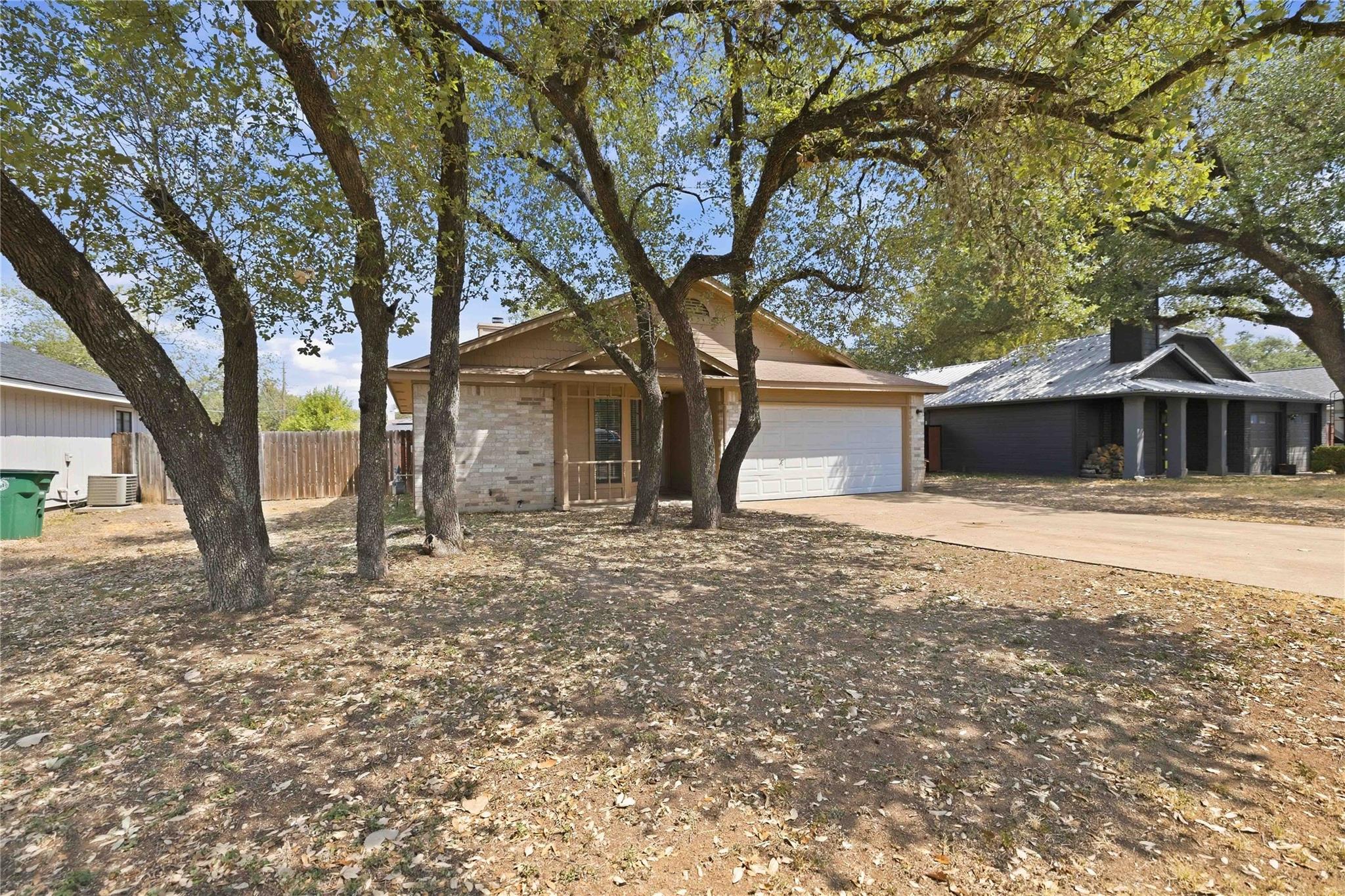 Mature shade trees frame this classic brick front