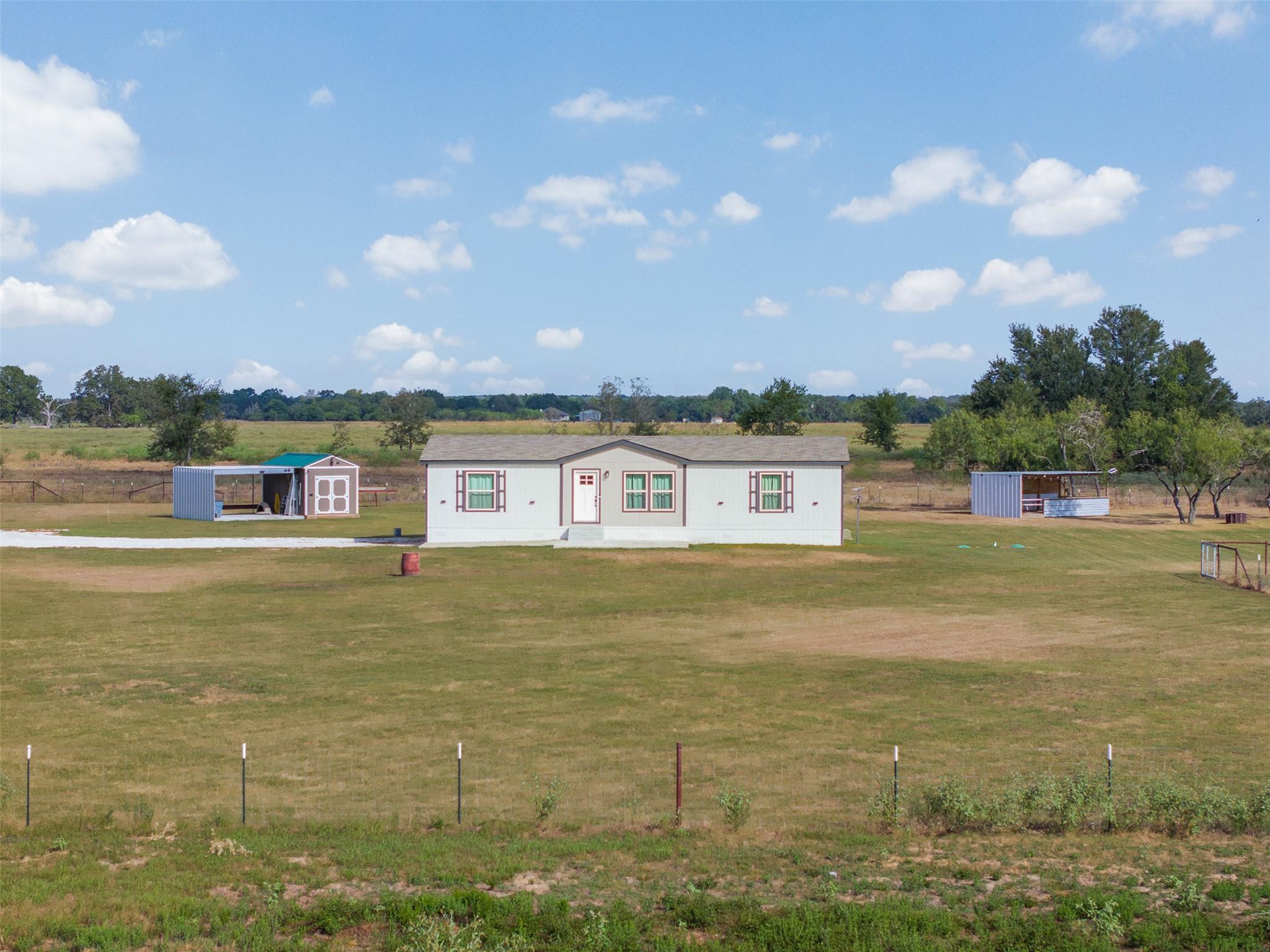 An expansive rural property sits under open blue 