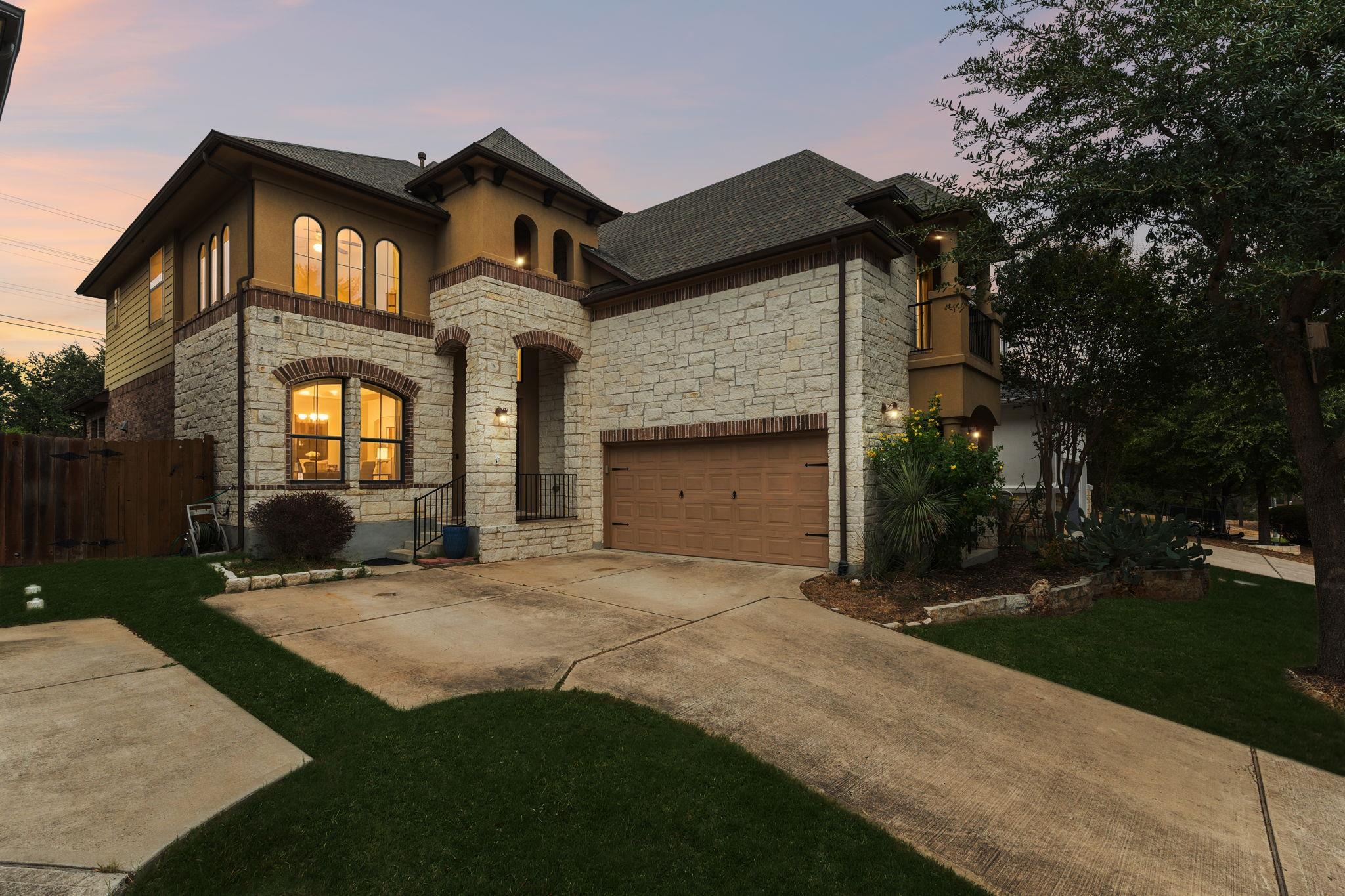 An elegant stone and stucco exterior stands beaut