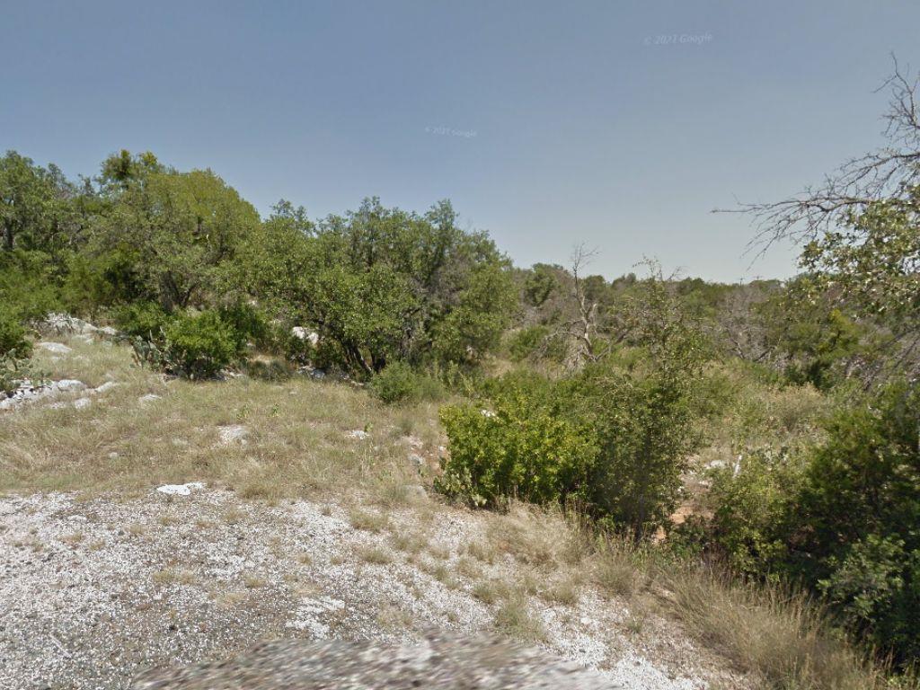 Mature trees and native vegetation surround a rug